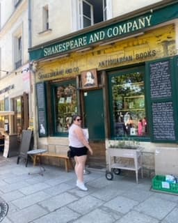 Debbie posing in front of a shop outside.
