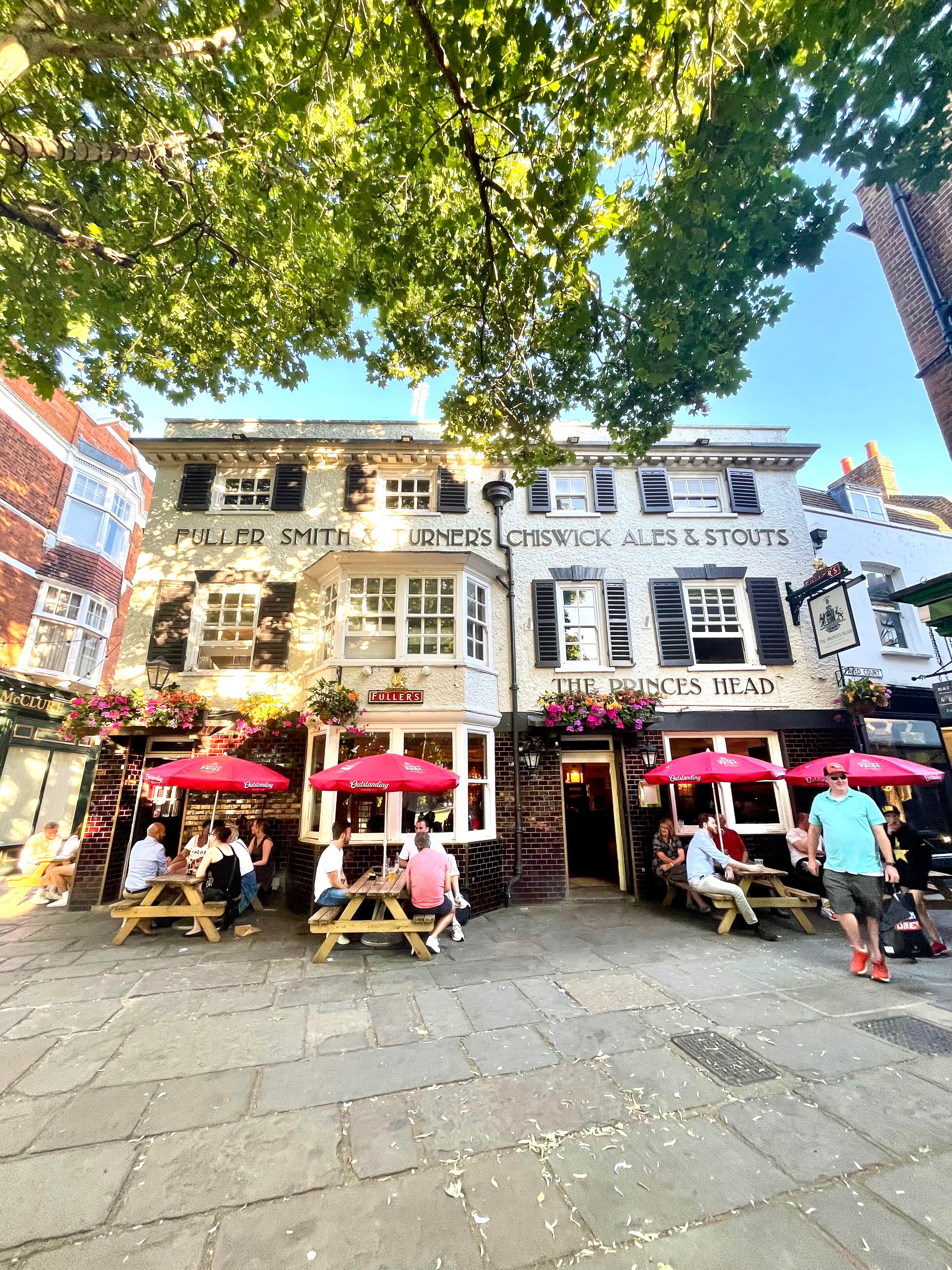 View of a building with little umbrellas outside of it during the daytime.