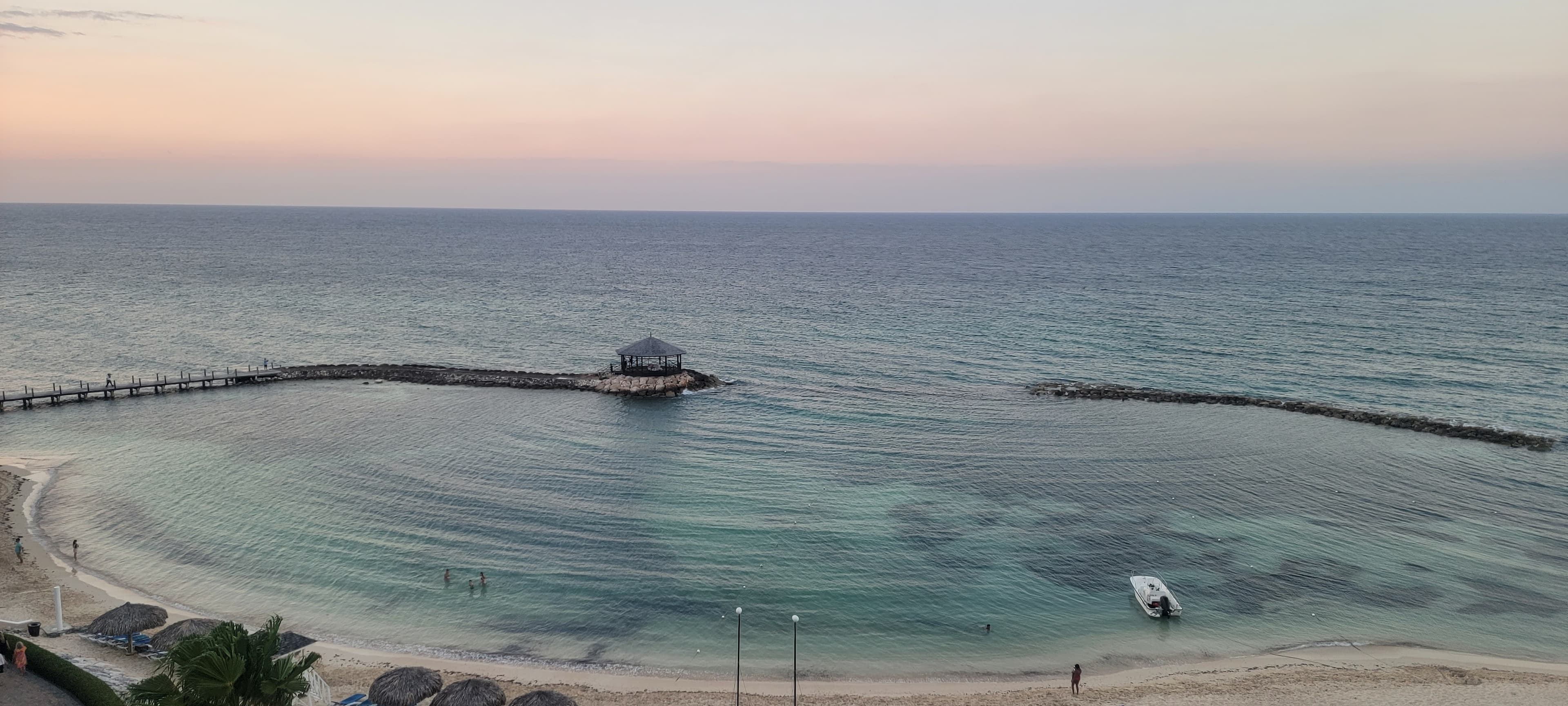 A view of the ocean complete with a beach, boardwalk, and viewing point.