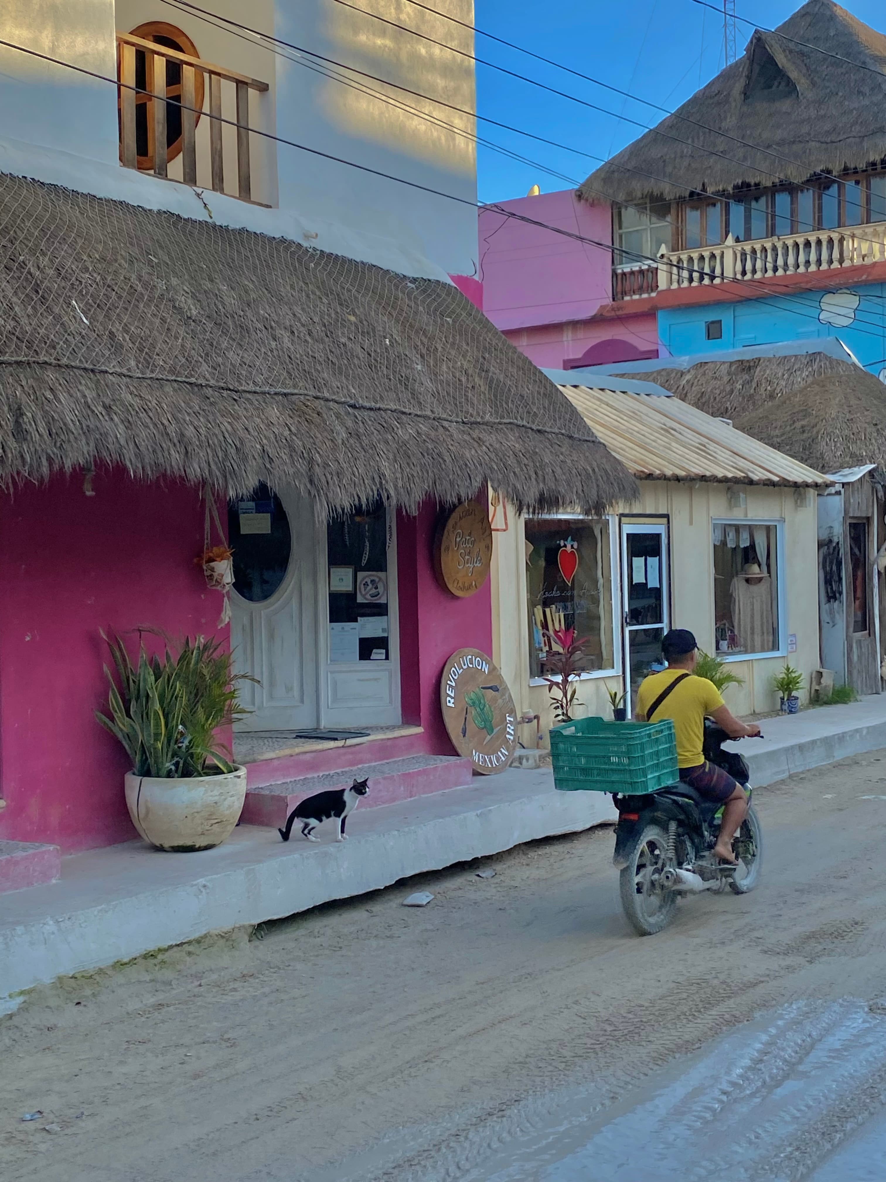 A man in a scooter in a village during the daytime.