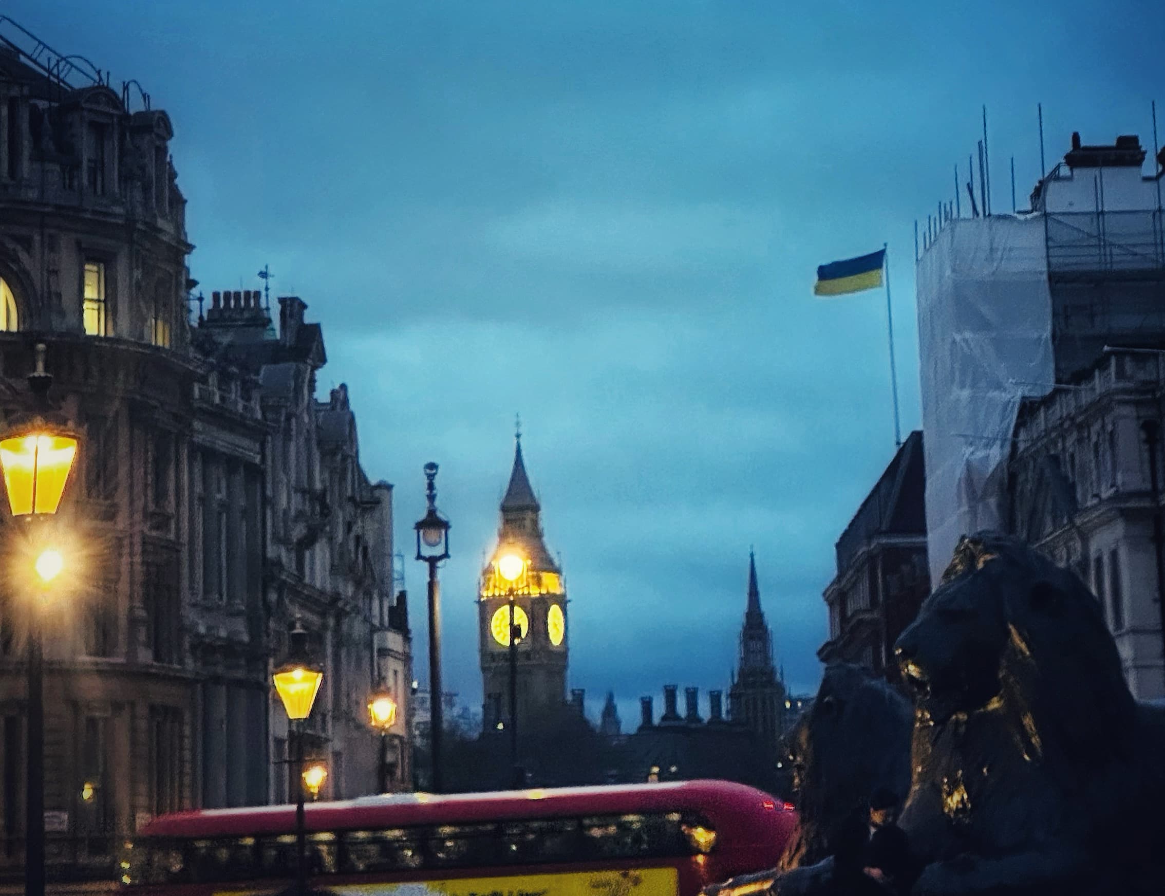 View of a foggy London street at dusk with Big Ben lit up in the distance