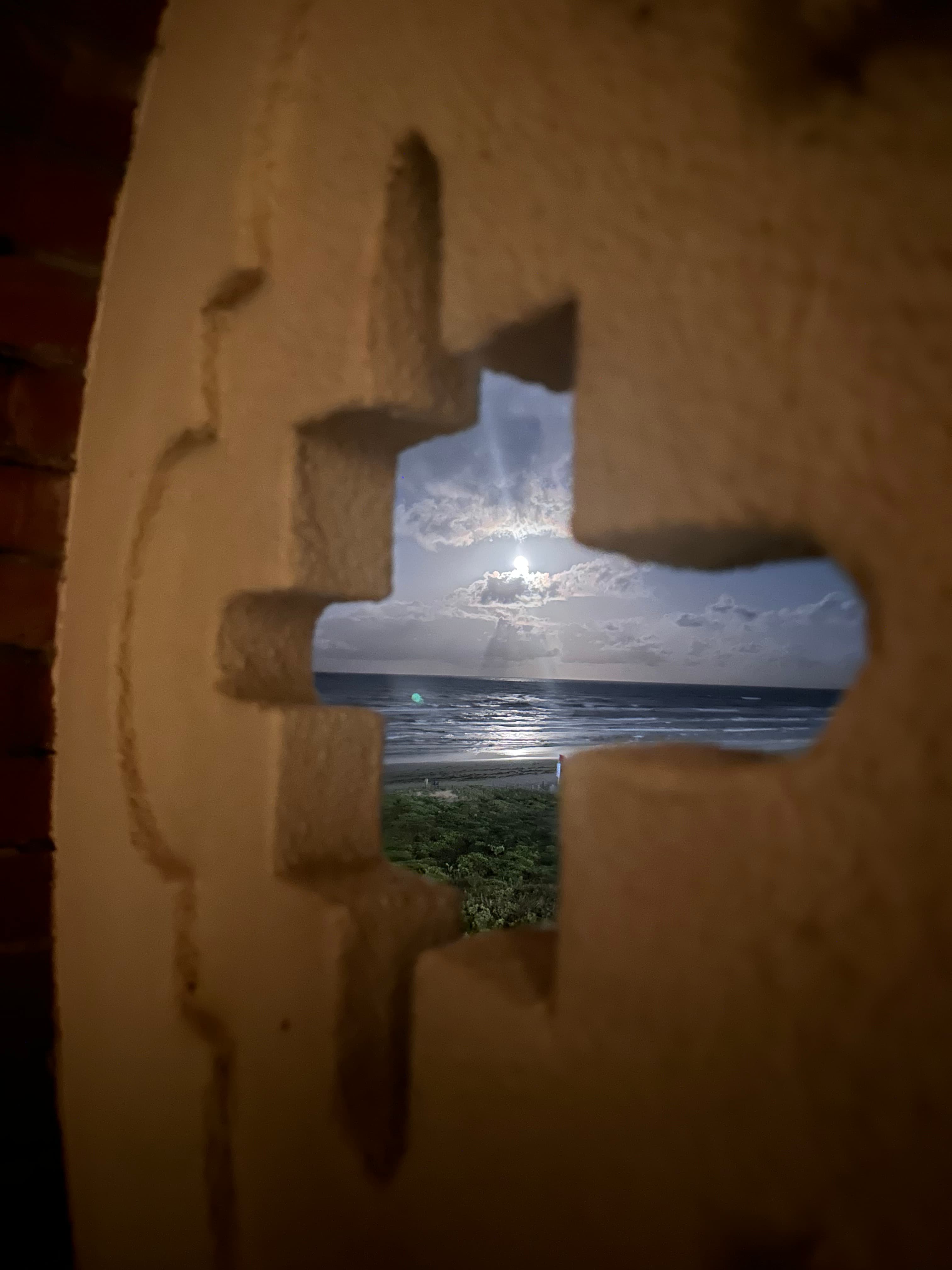 View of sun over ocean through a window.