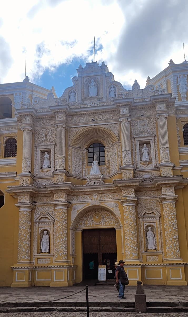 A church stands tall against a bright sky scattered with clouds.