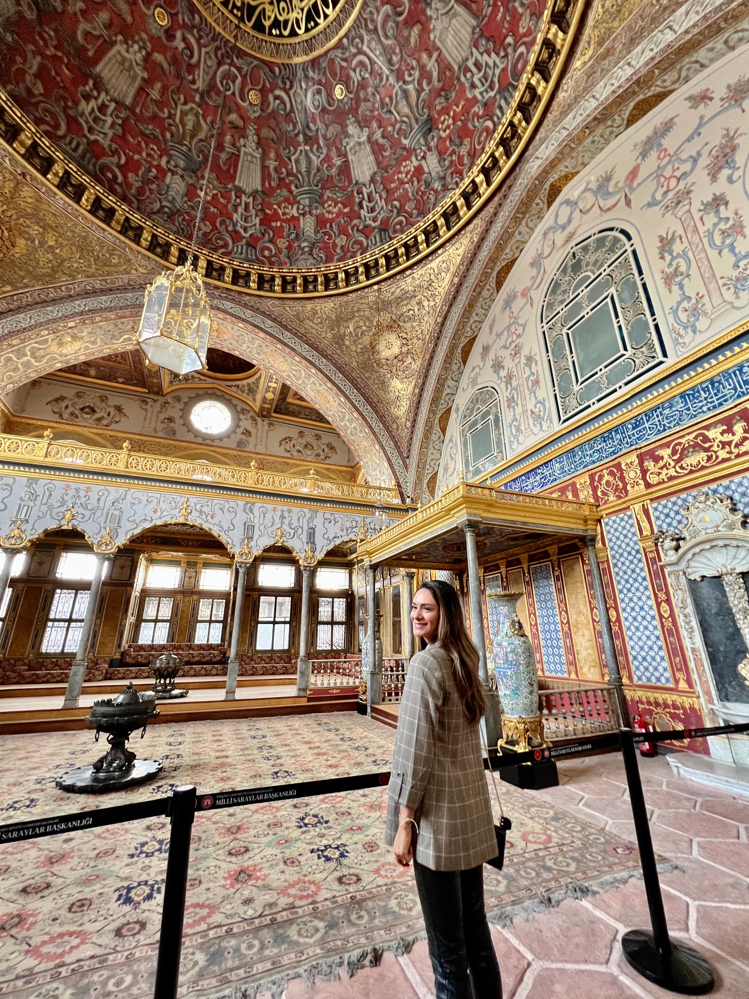 Advisor smiling over her shoulder in an ornately decorated temple with domed ceilings and mosaic floors