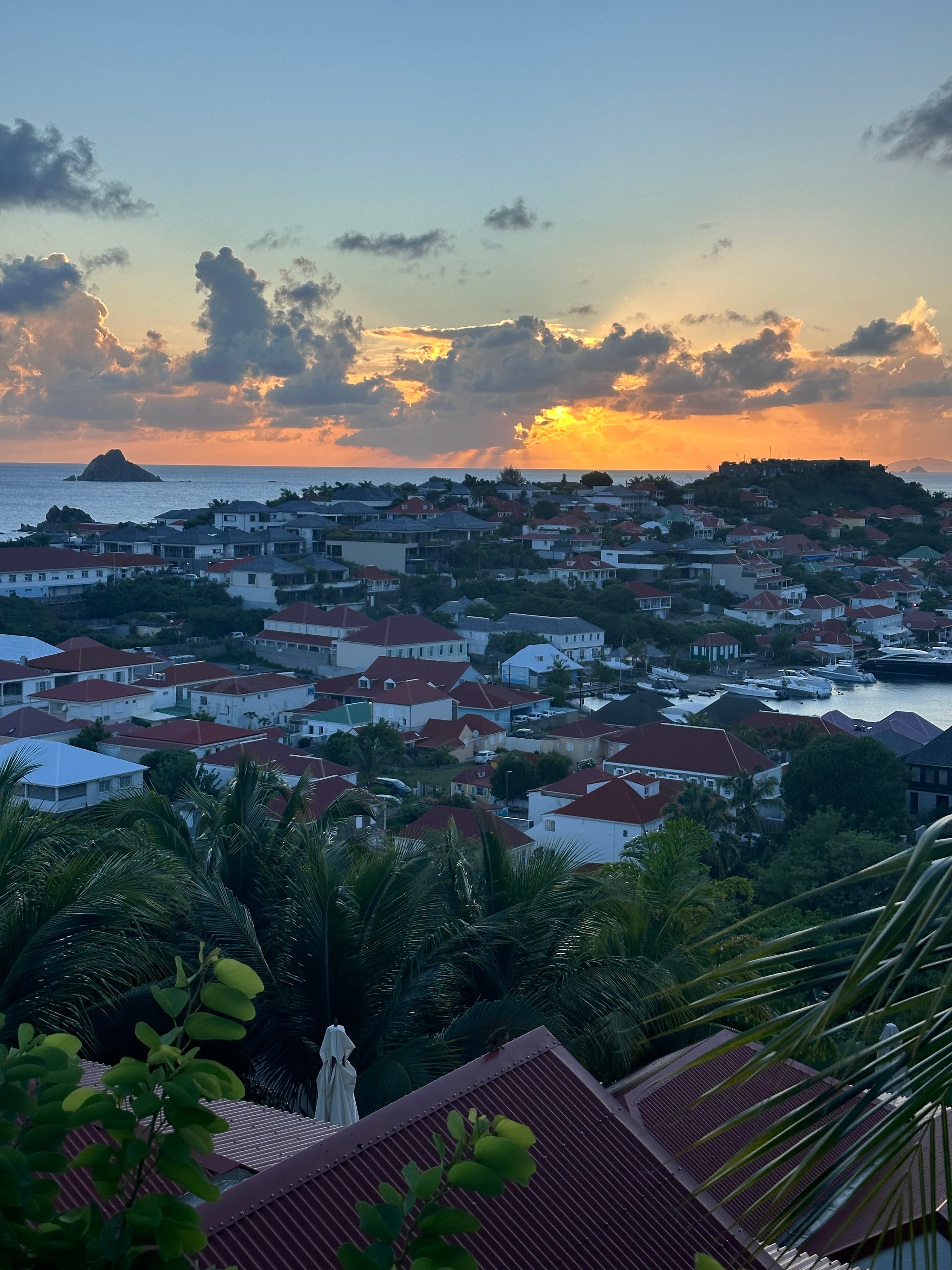 Sunset view from the Columbier Suite at Le Carl Gustaf, St. Barths as the town reaches to the sea.