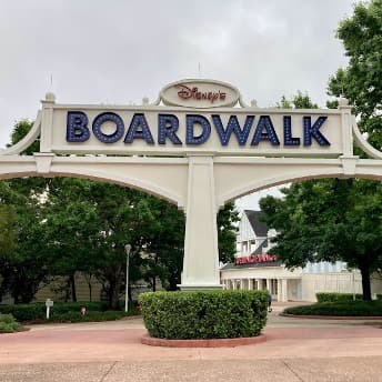 A white gated entrance to Disney Broadwalk.