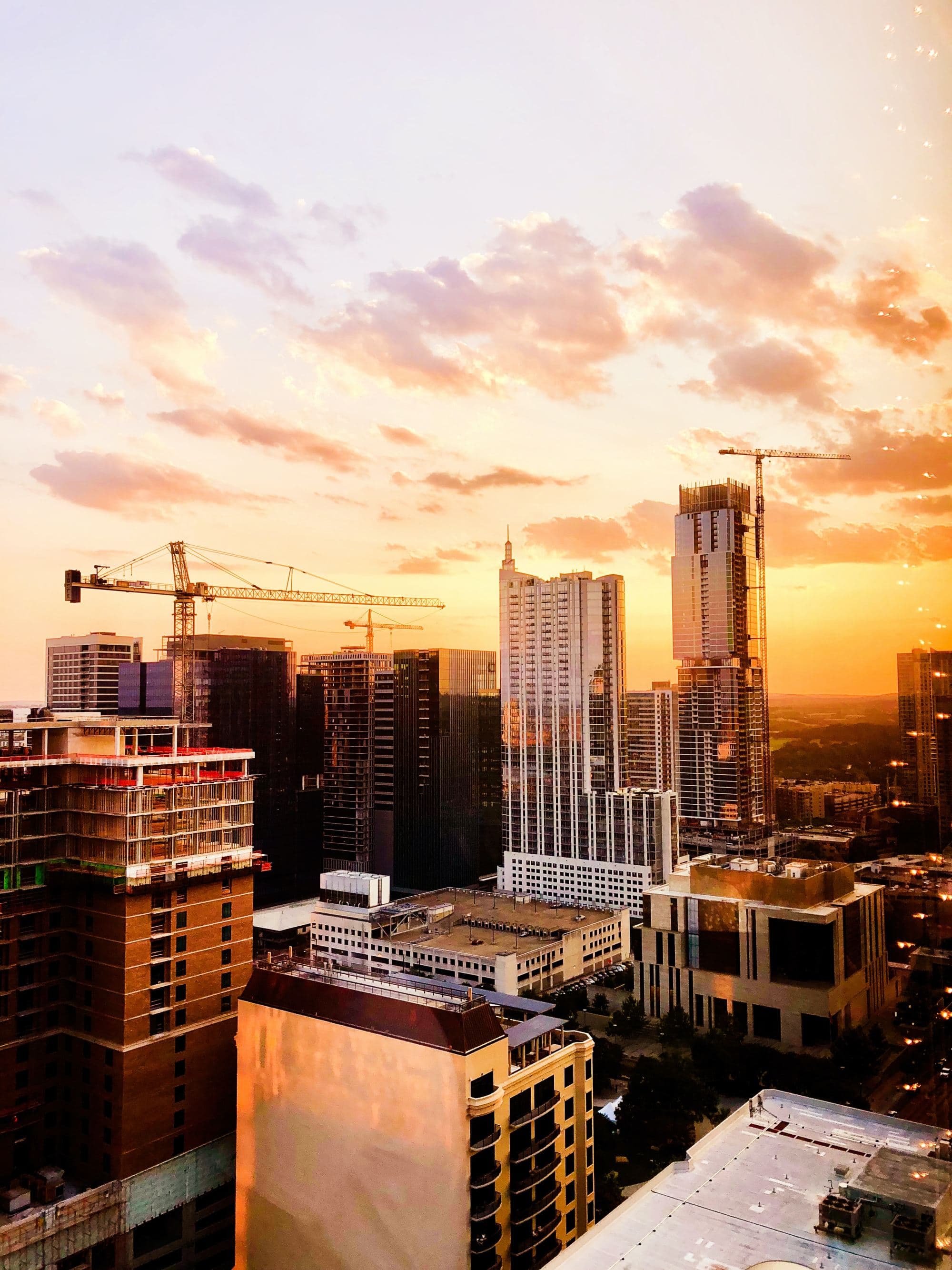 sunset over modern city reflects on skyscrapers