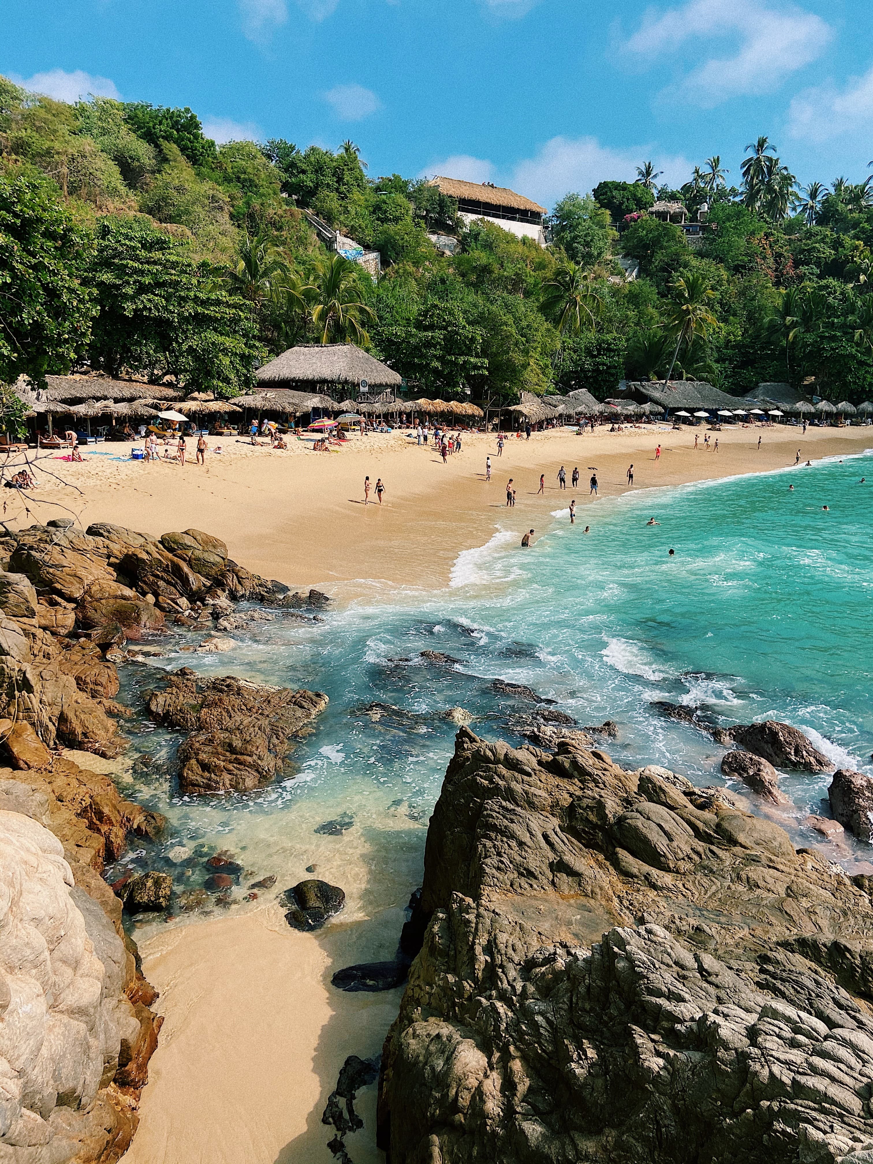 rocks next to beach and body of water during daytime