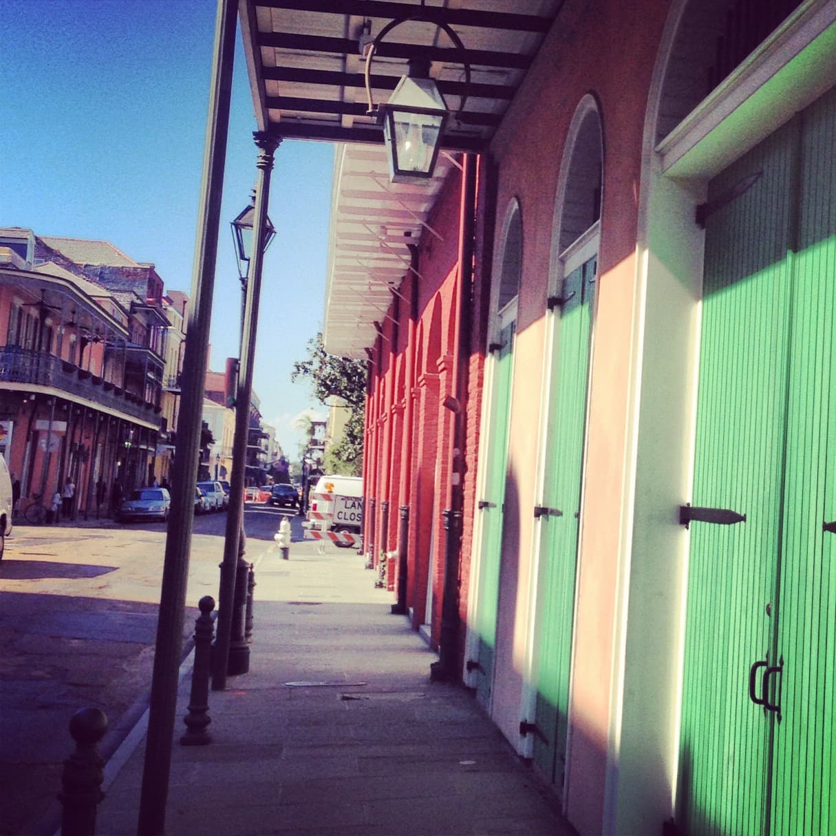 A pathway in street with green doors.