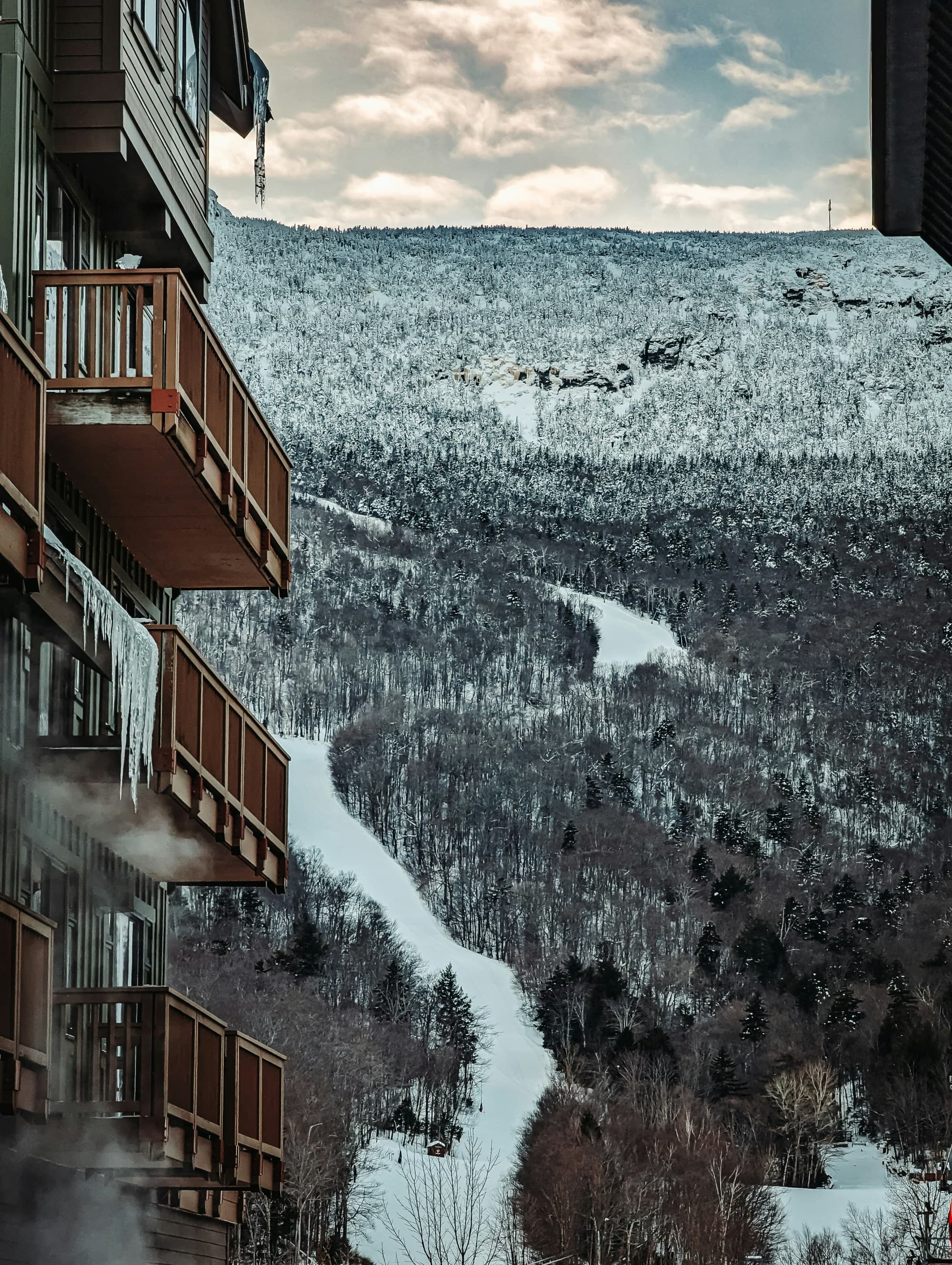 An aerial view of the resort and the mountains covered in snow during the daytime