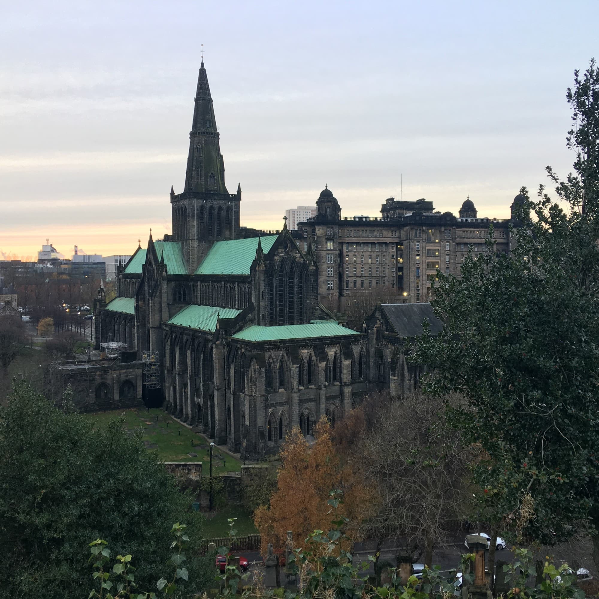 A cathedral with green roofing and trees around.