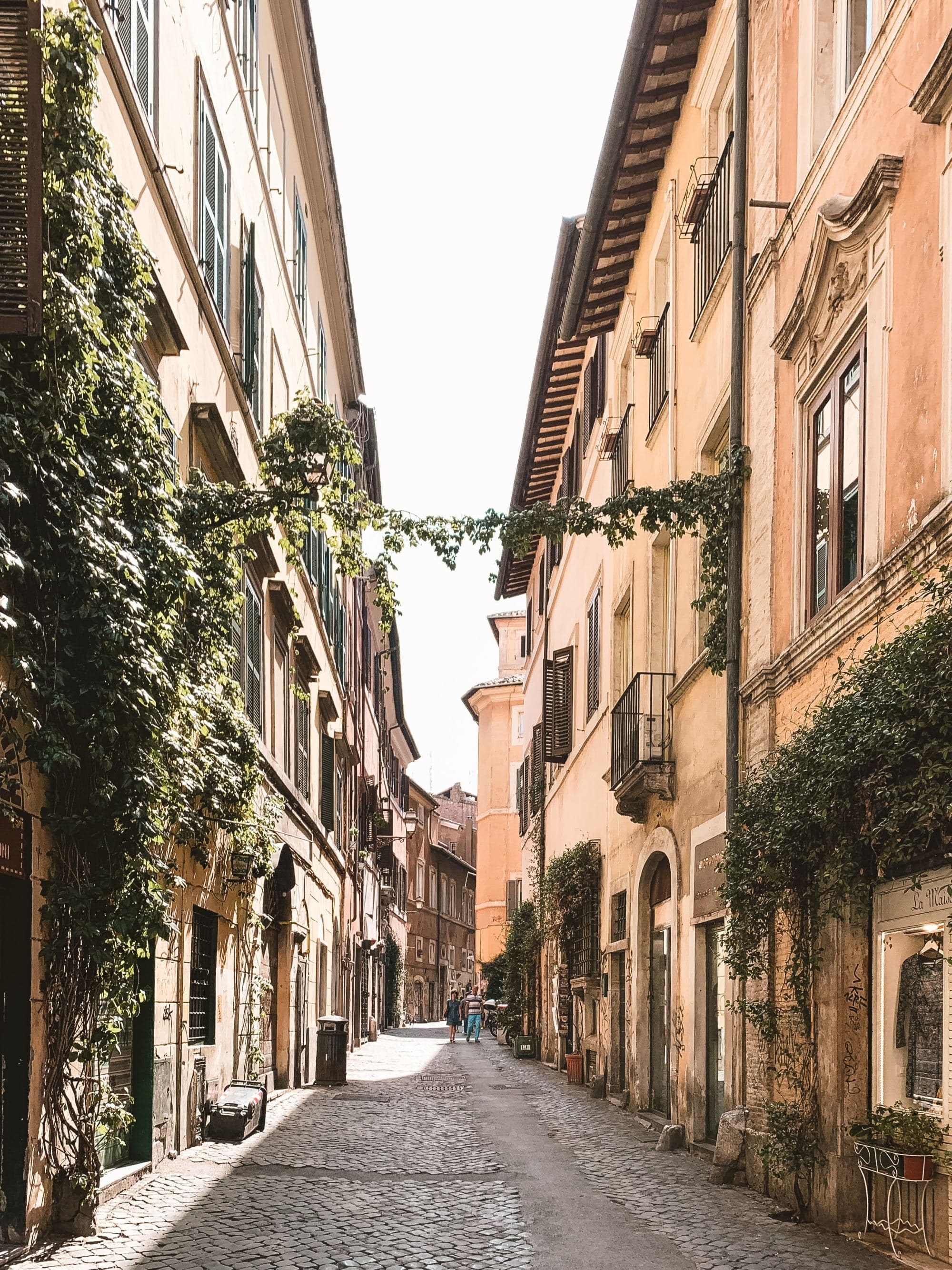 a small empty street in a historic city with ivy covered buildings