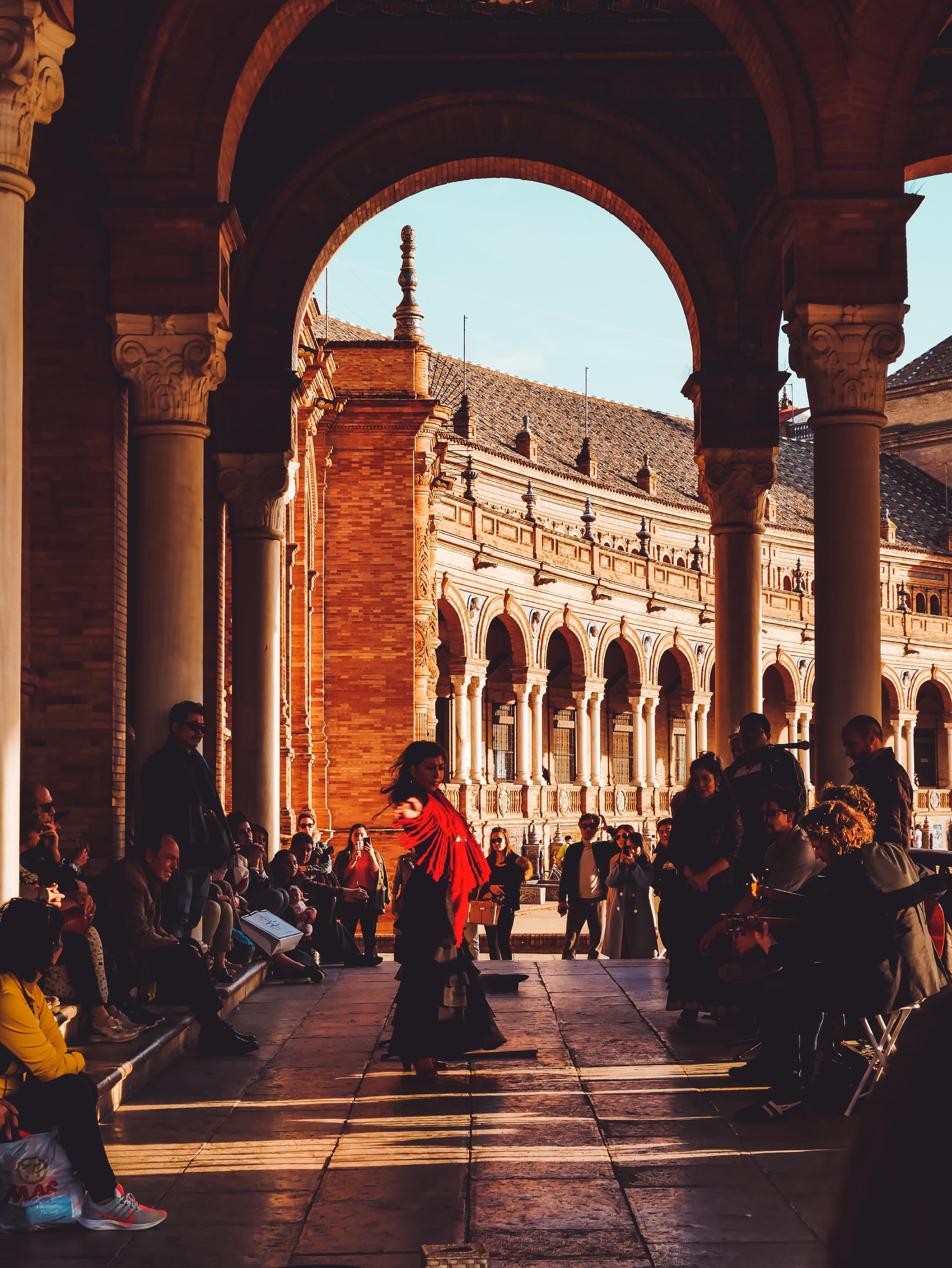 people dancing under a large archway during daytime