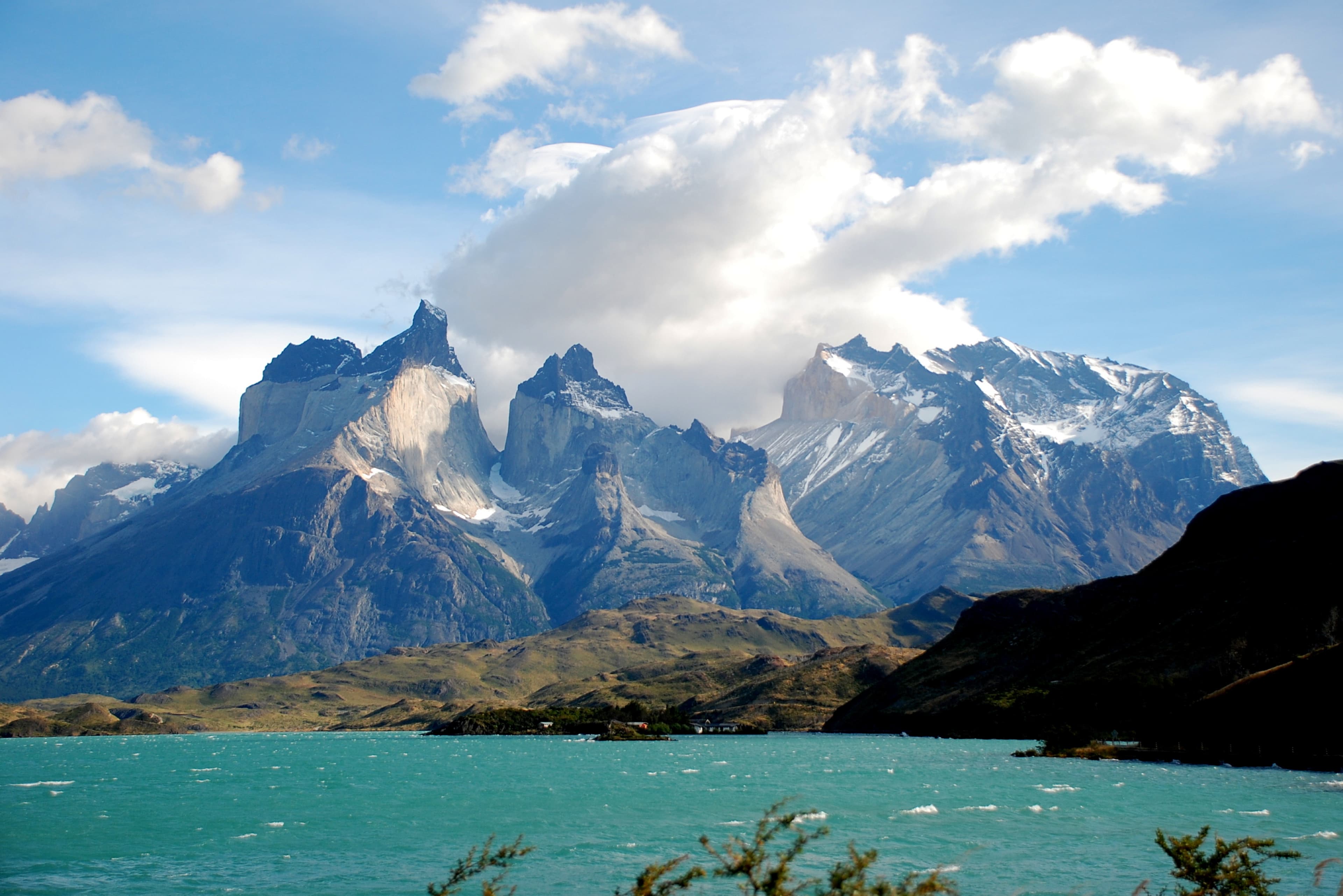 bright blue lake with sharp snow-capped mountains during daytime