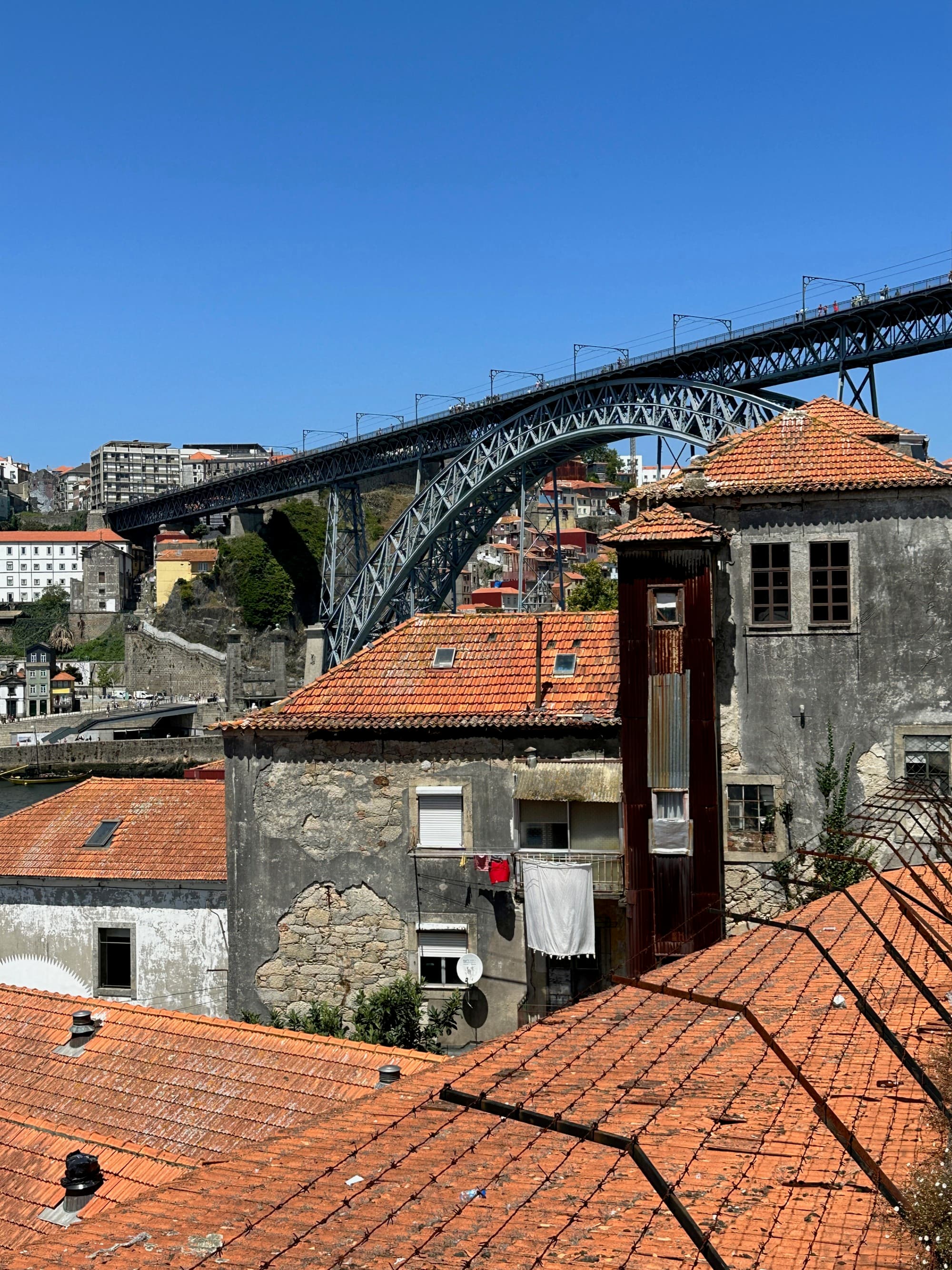 Buildings with orange roofs and bridge at the back during daytime.