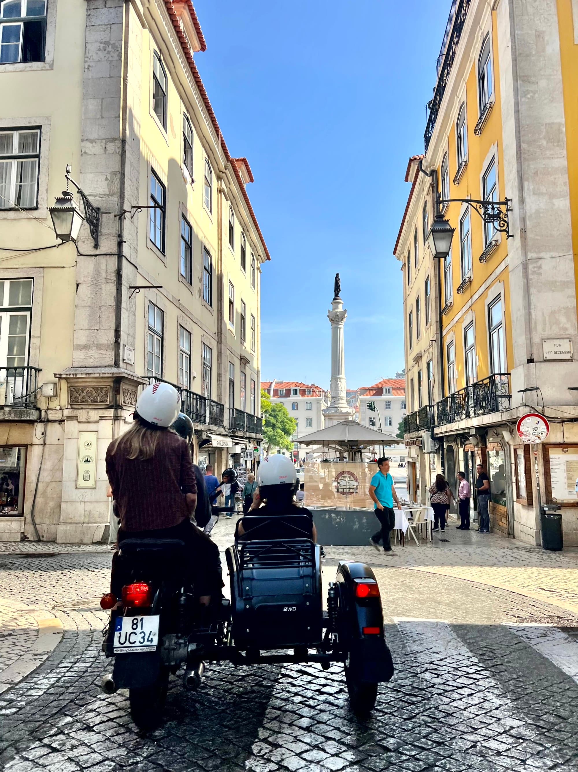 A picture of people in a streetcar on the street during daytime.