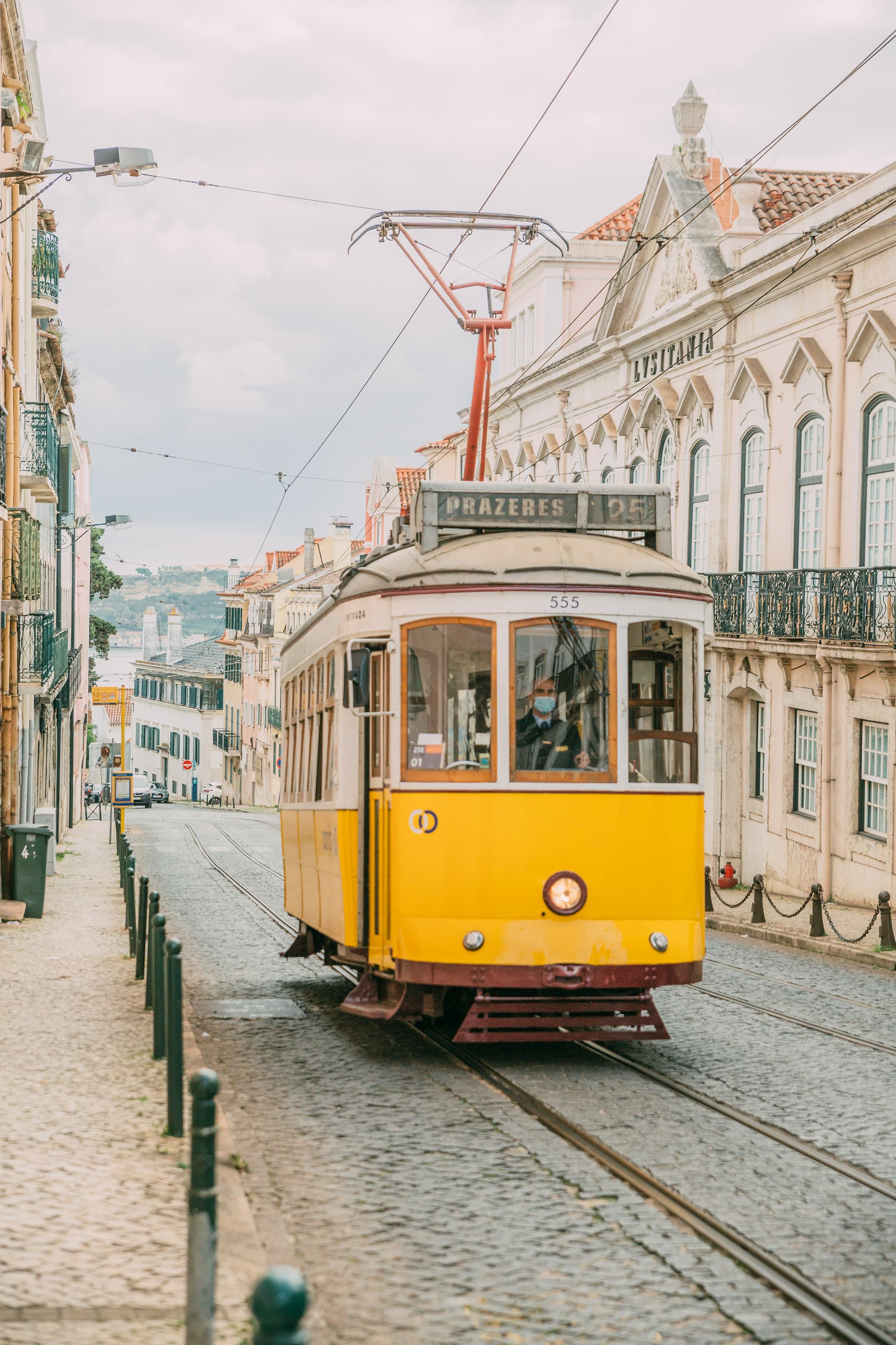 Yellow and white tram on the road