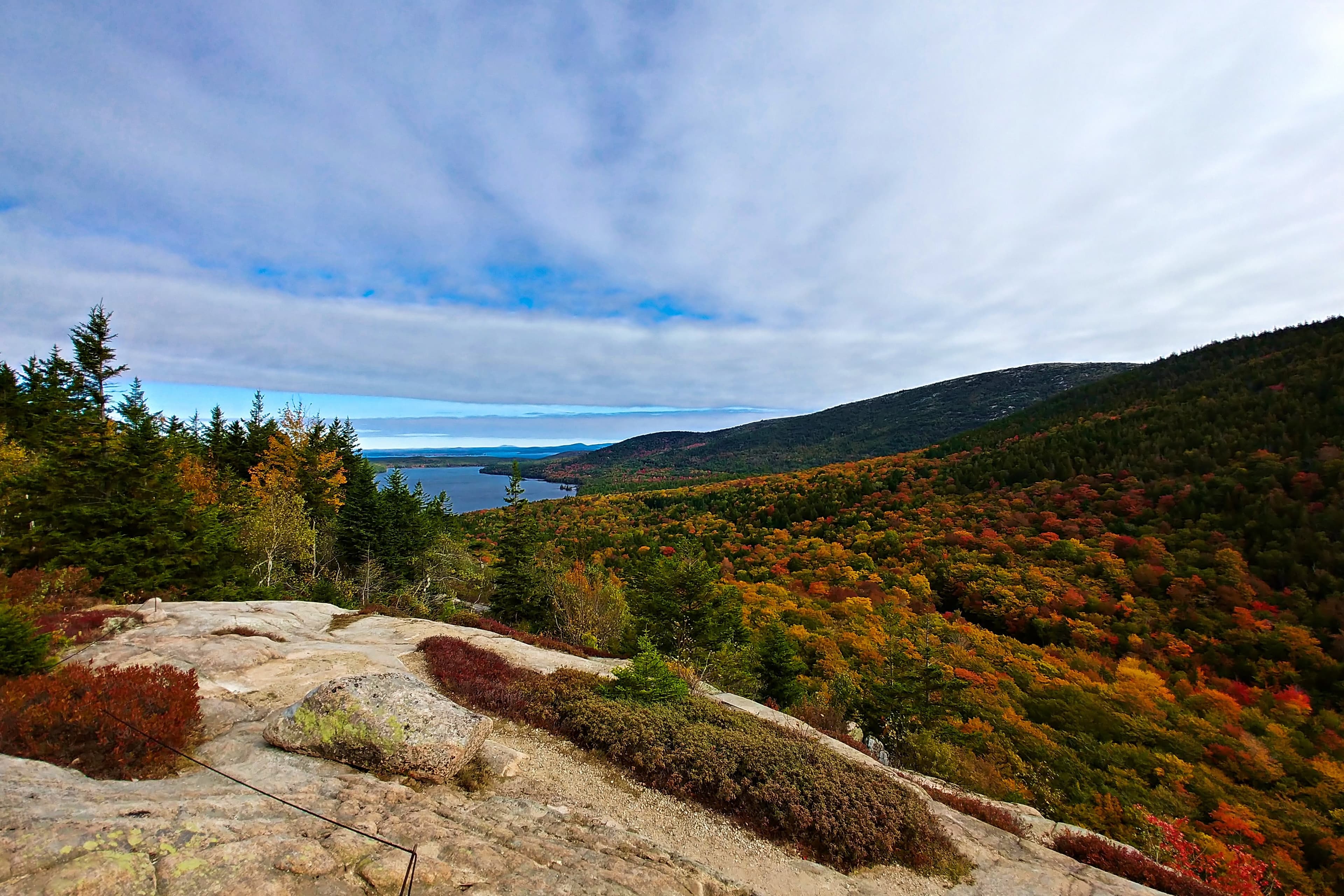 Green and brown mountains near blue sea