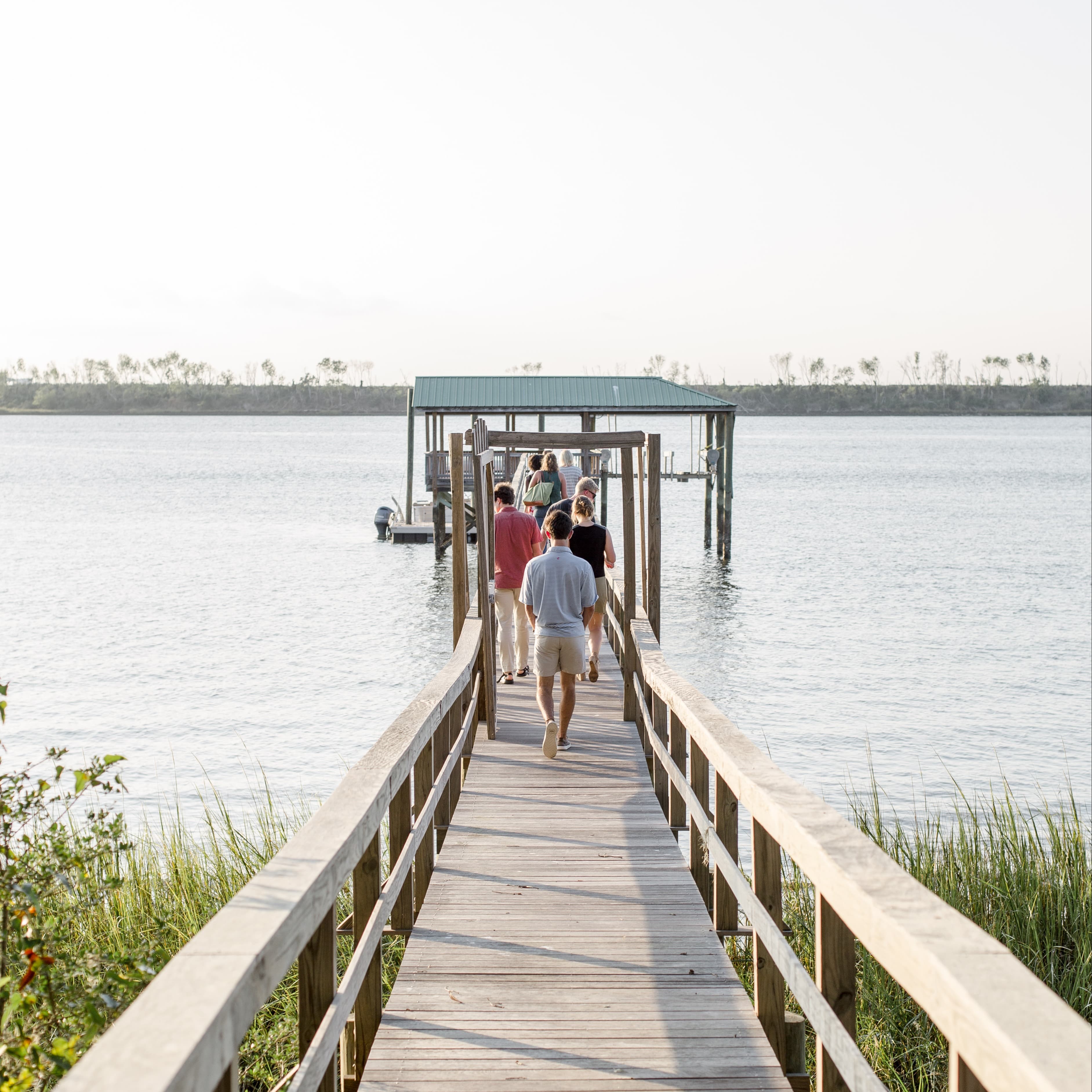 A small bridge on a beach going into water.