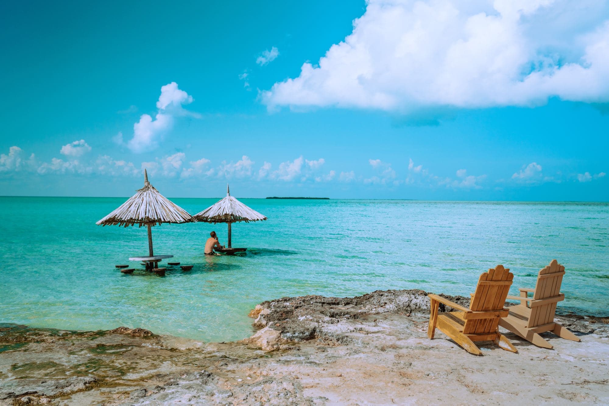 two thatched umbrellas in a turquoise sea