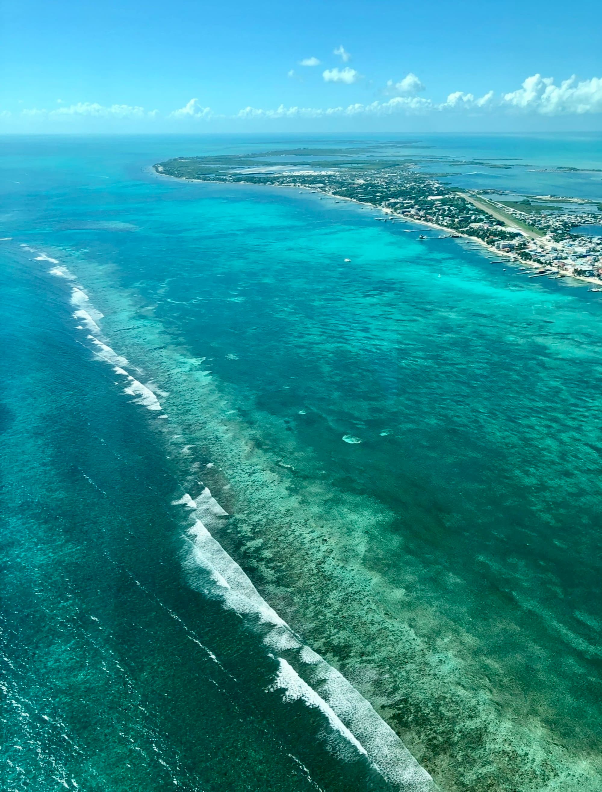 An aerial view of emerald and green-like water on a beautiful day.