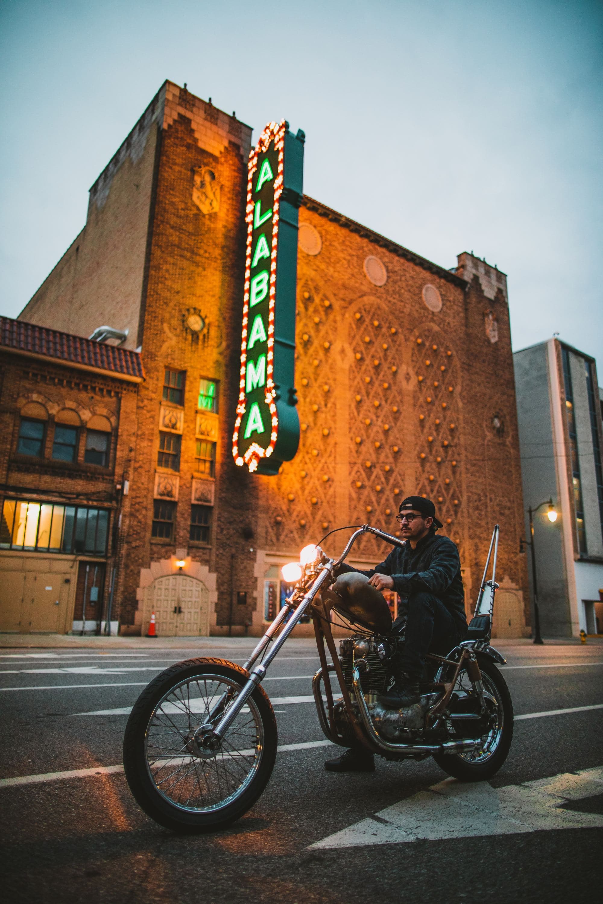 Man riding on cruiser Motocycle near Alabama signage.
