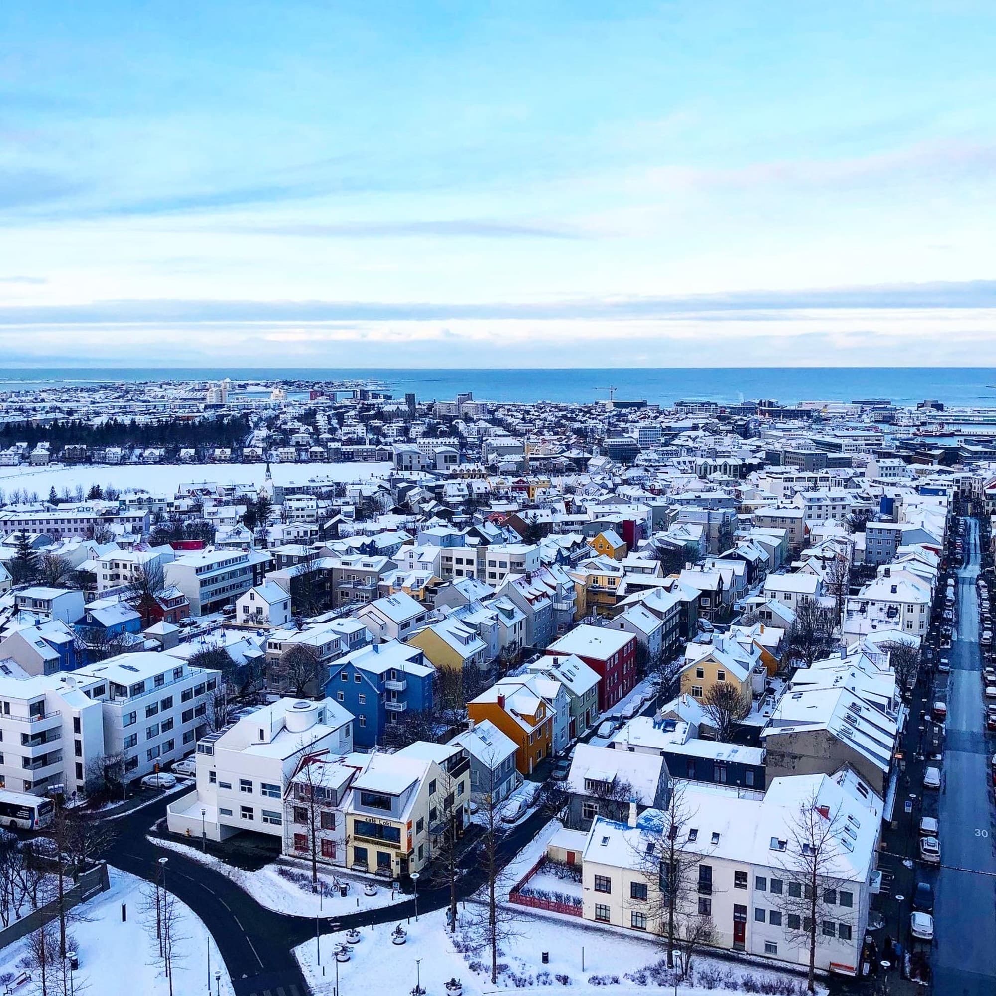 An aerial view from of the houses in a snowy city during daytime.