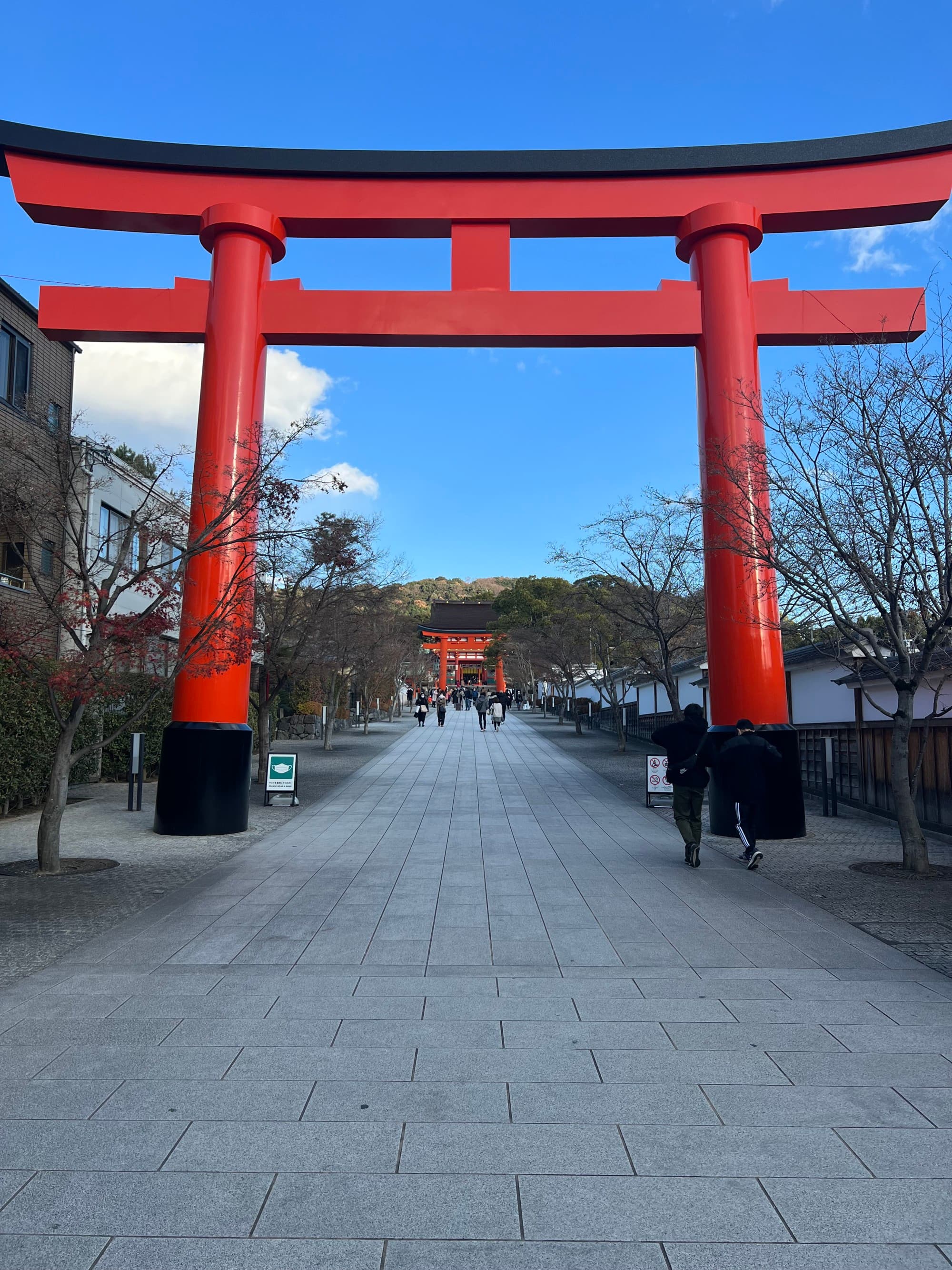 Red pillars with a stone pathway and trees.