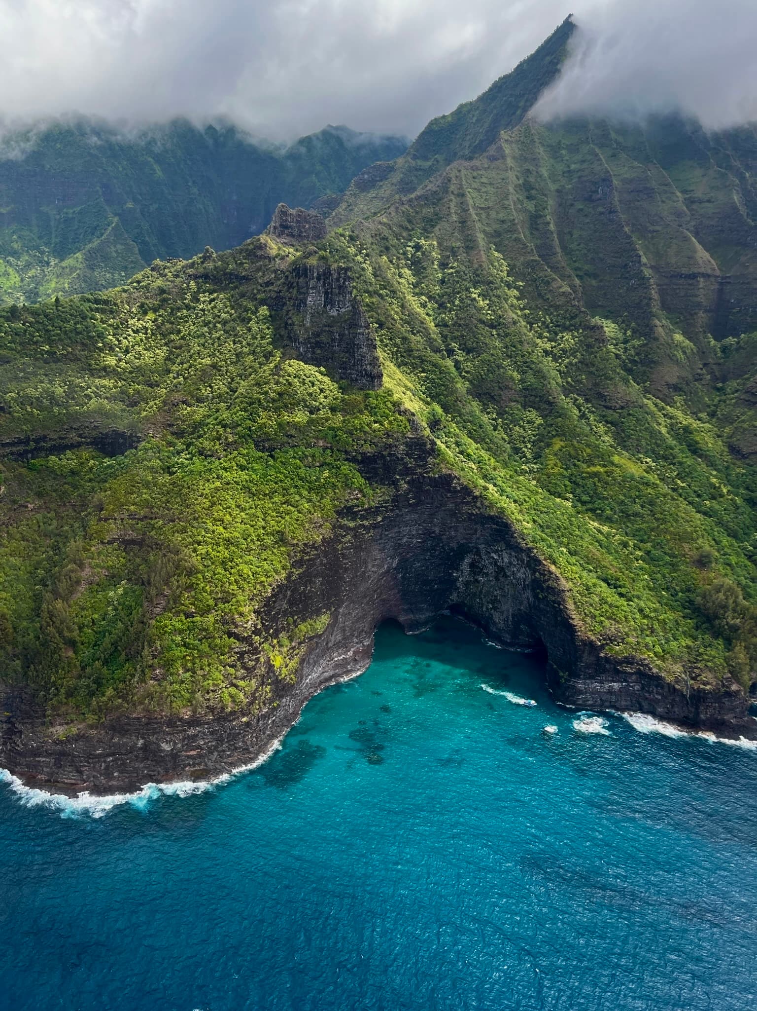 aerial view of green mountain next to body of water