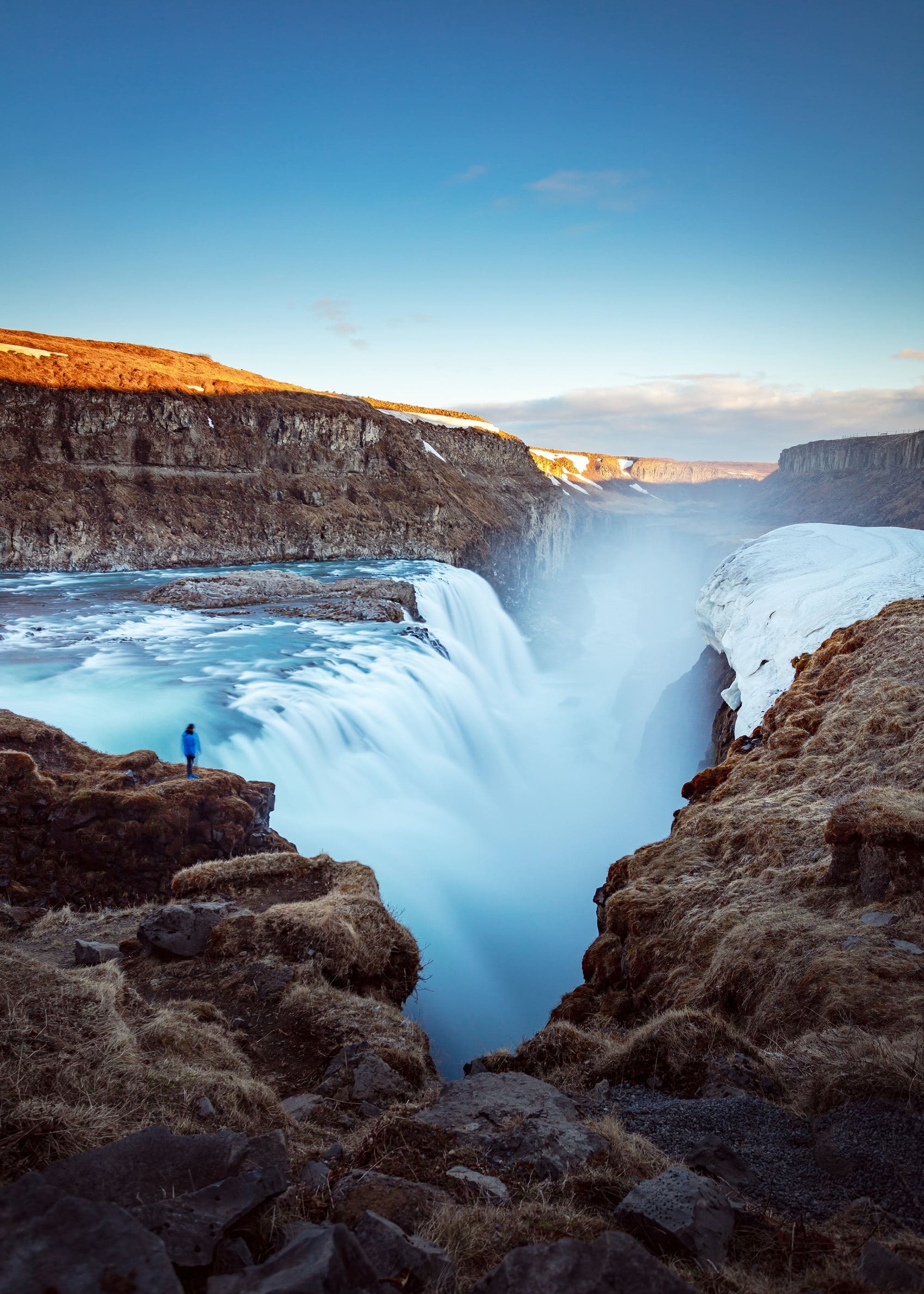 An aerial view of the waterfalls near a cliff during daytime