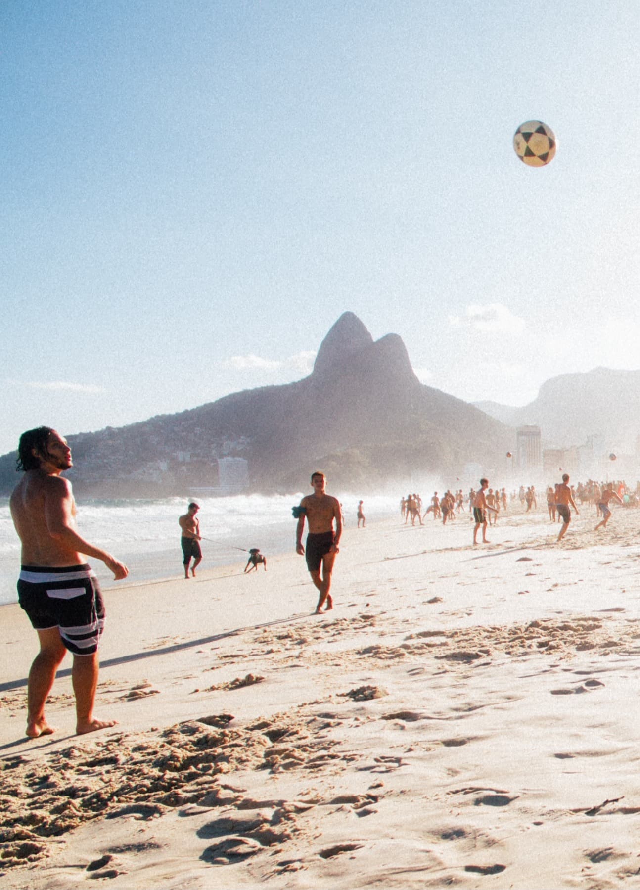 People playing volleyball on the beach.