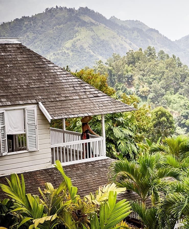 Aerial view of a house near a forest of green trees