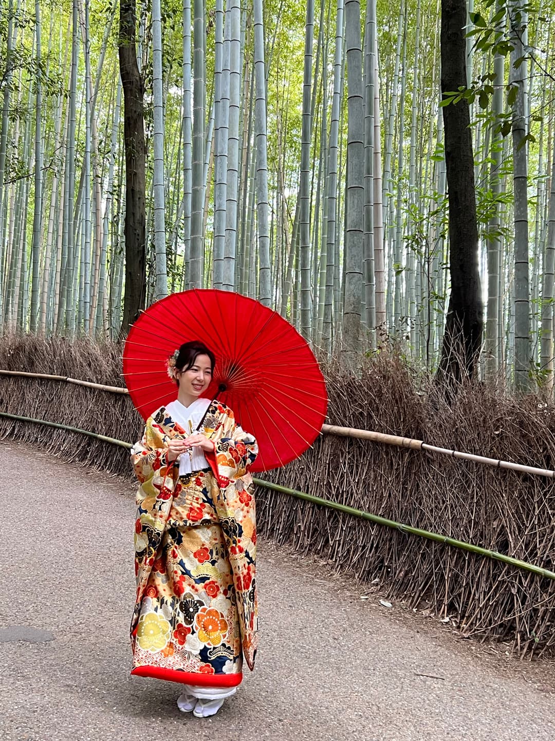 A woman in traditional Japanese dress holding a red umbrella.