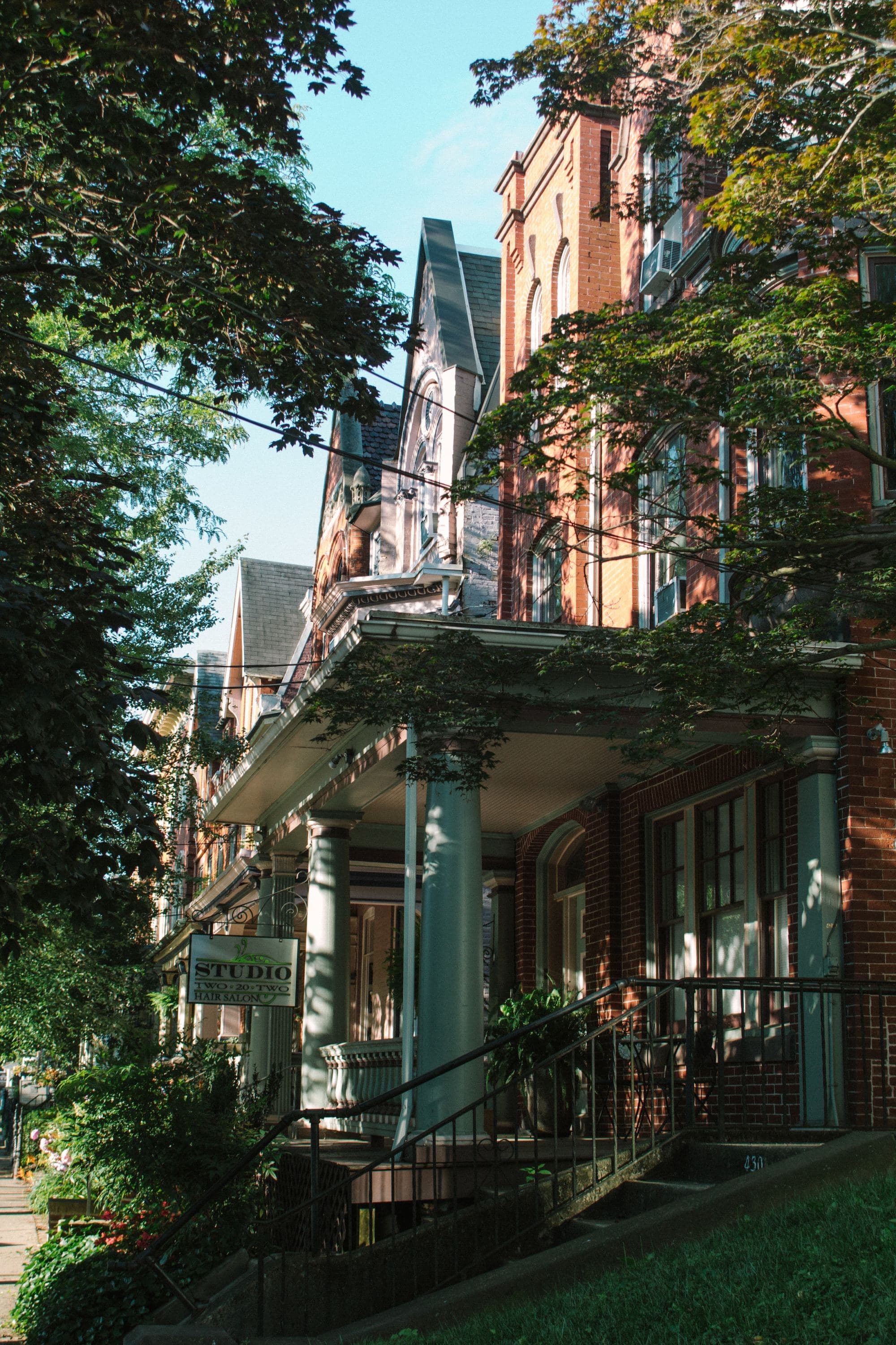 grand brick home shaded by trees