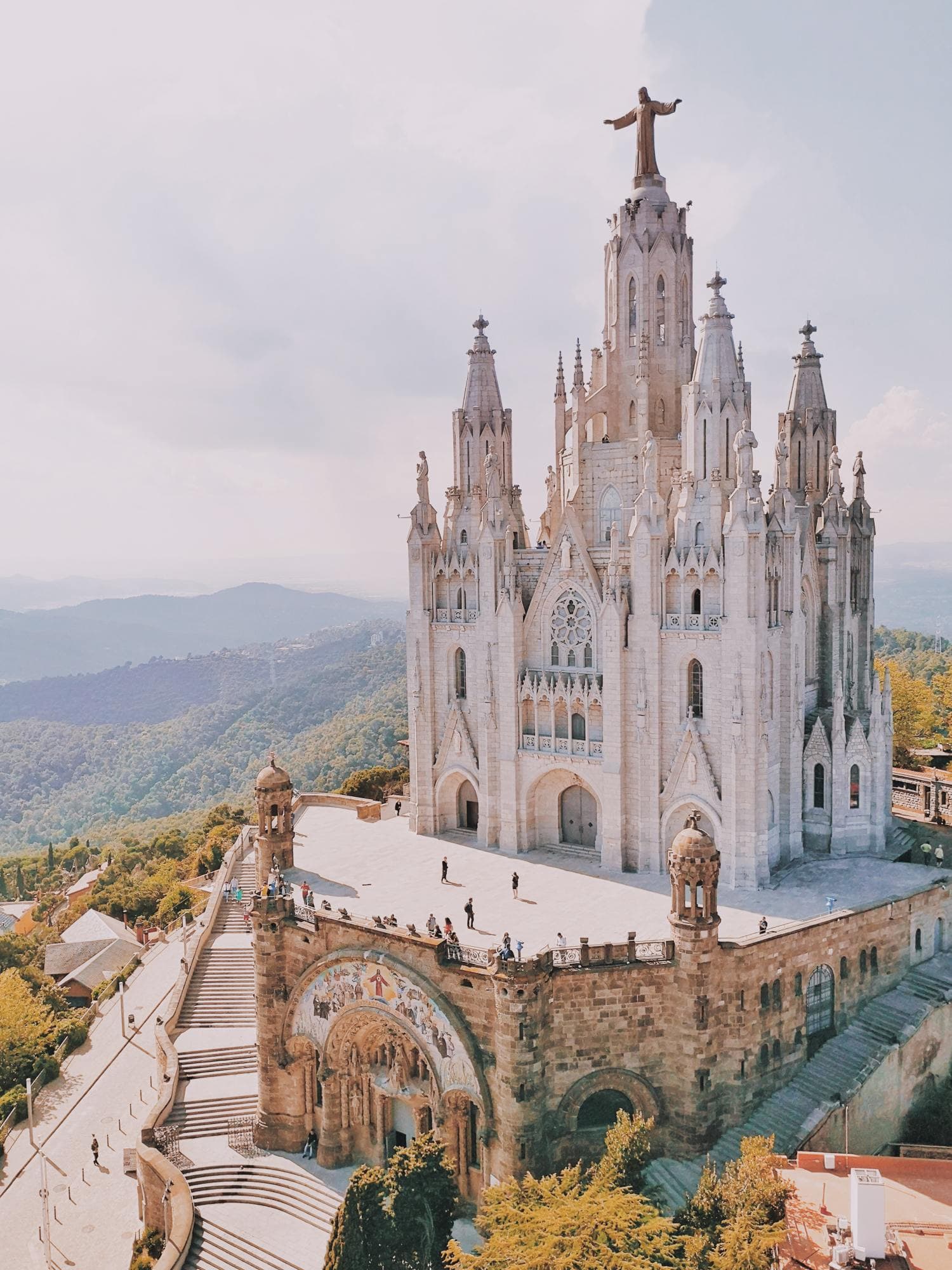 La Sagrada Familia on a sunny day in autumn surrounded by lush greenery.