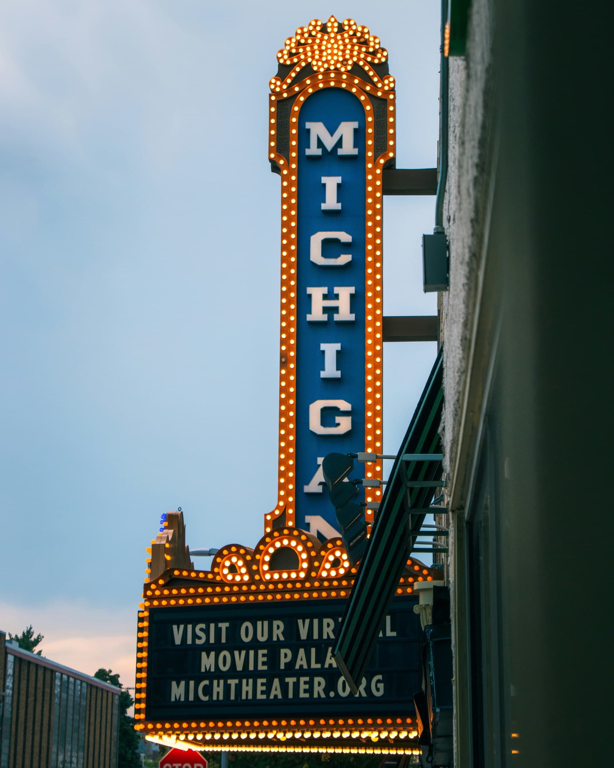 A retro movie theater sign on a building with the word "Michigan" written on it.
