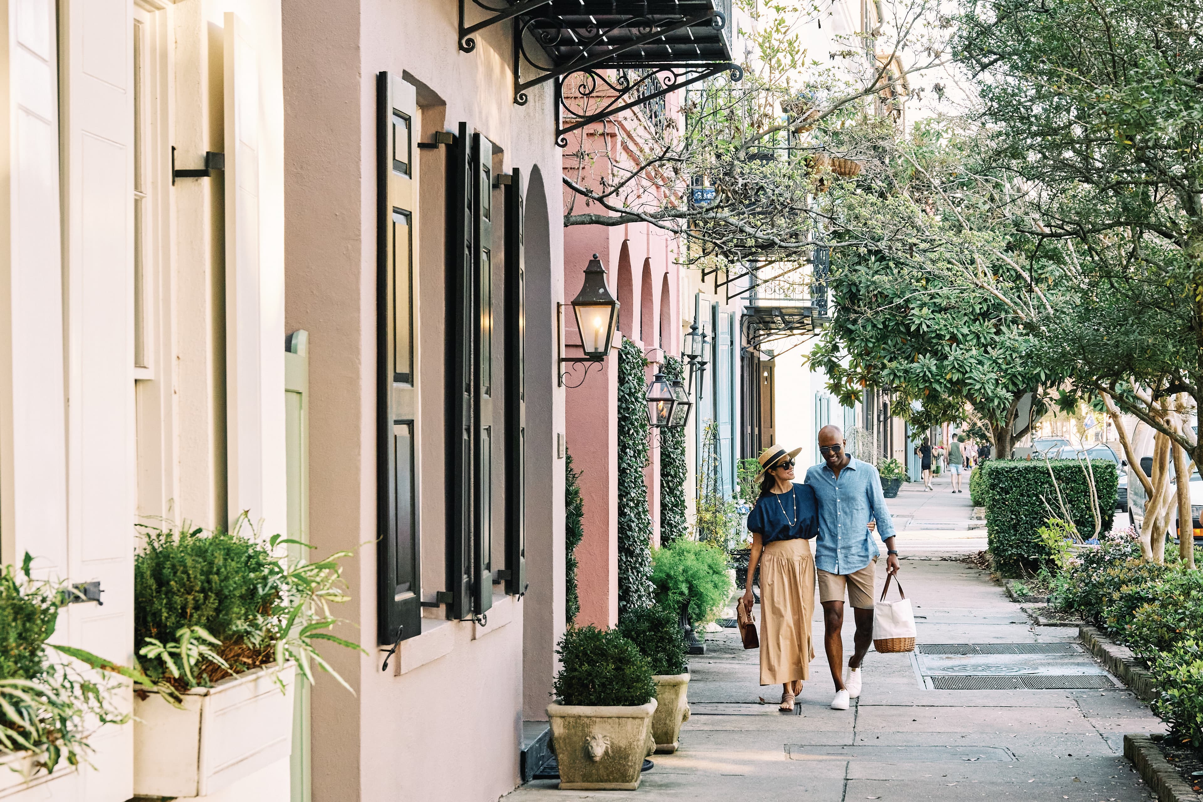 two people walking next to colorful buildings during daytime