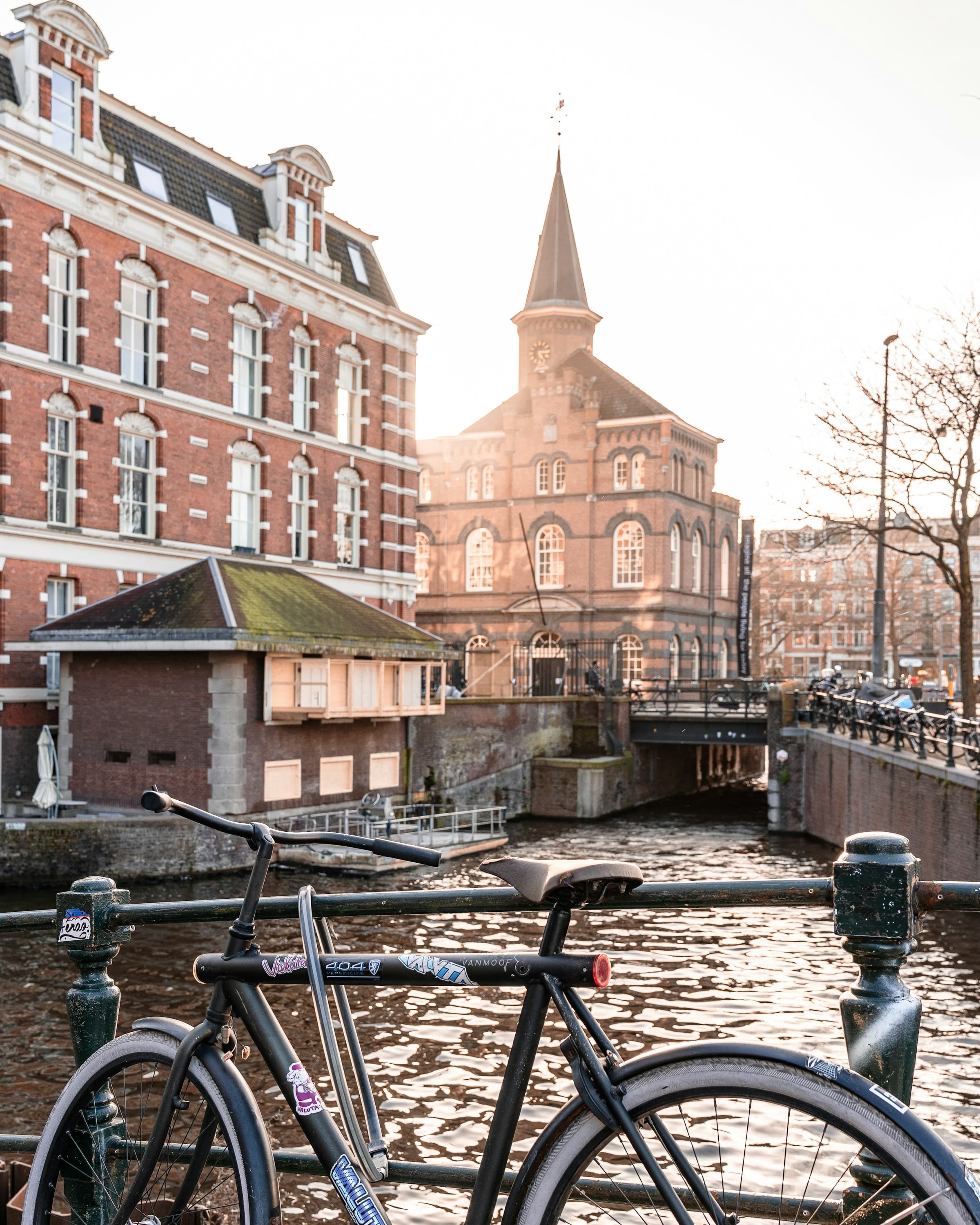 A bicycle against a railing over a canal during the daytime