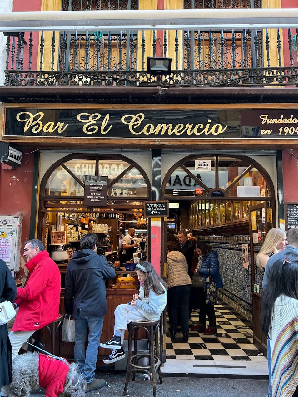 Outdoor sitting with people of a bar named Bar el comercio.