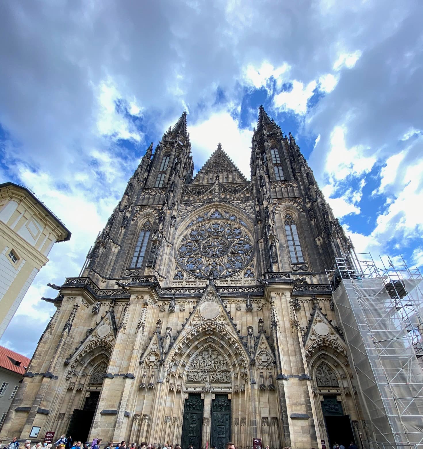 The amazing architecture of St. Vitus Cathedral in front of clouds and a blue sky.