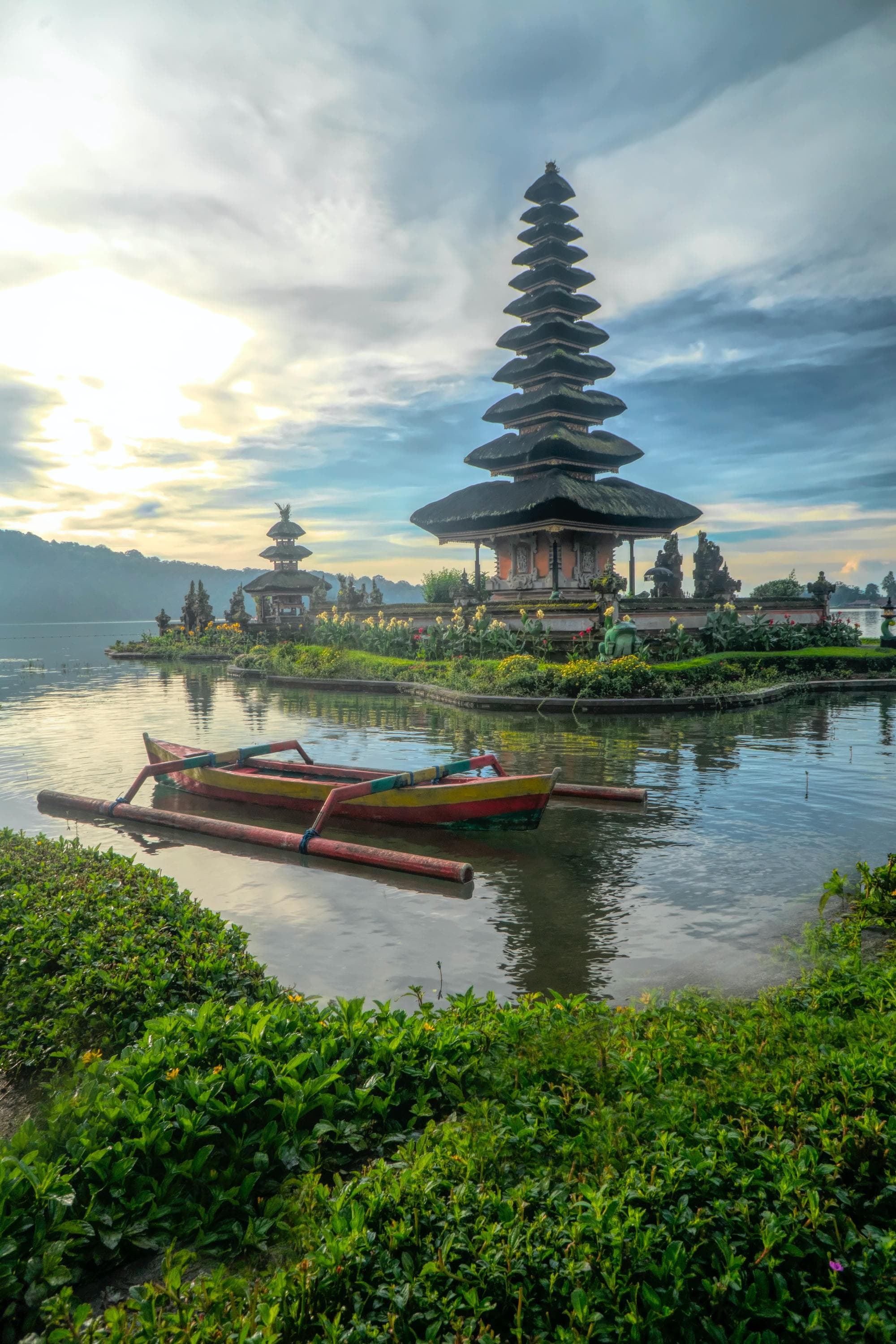 Canoe on body of water with pagoda background.