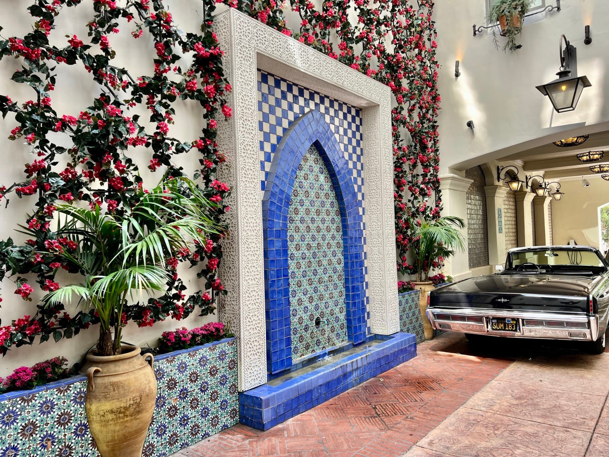 A car parked in the driveway of a decorated wall