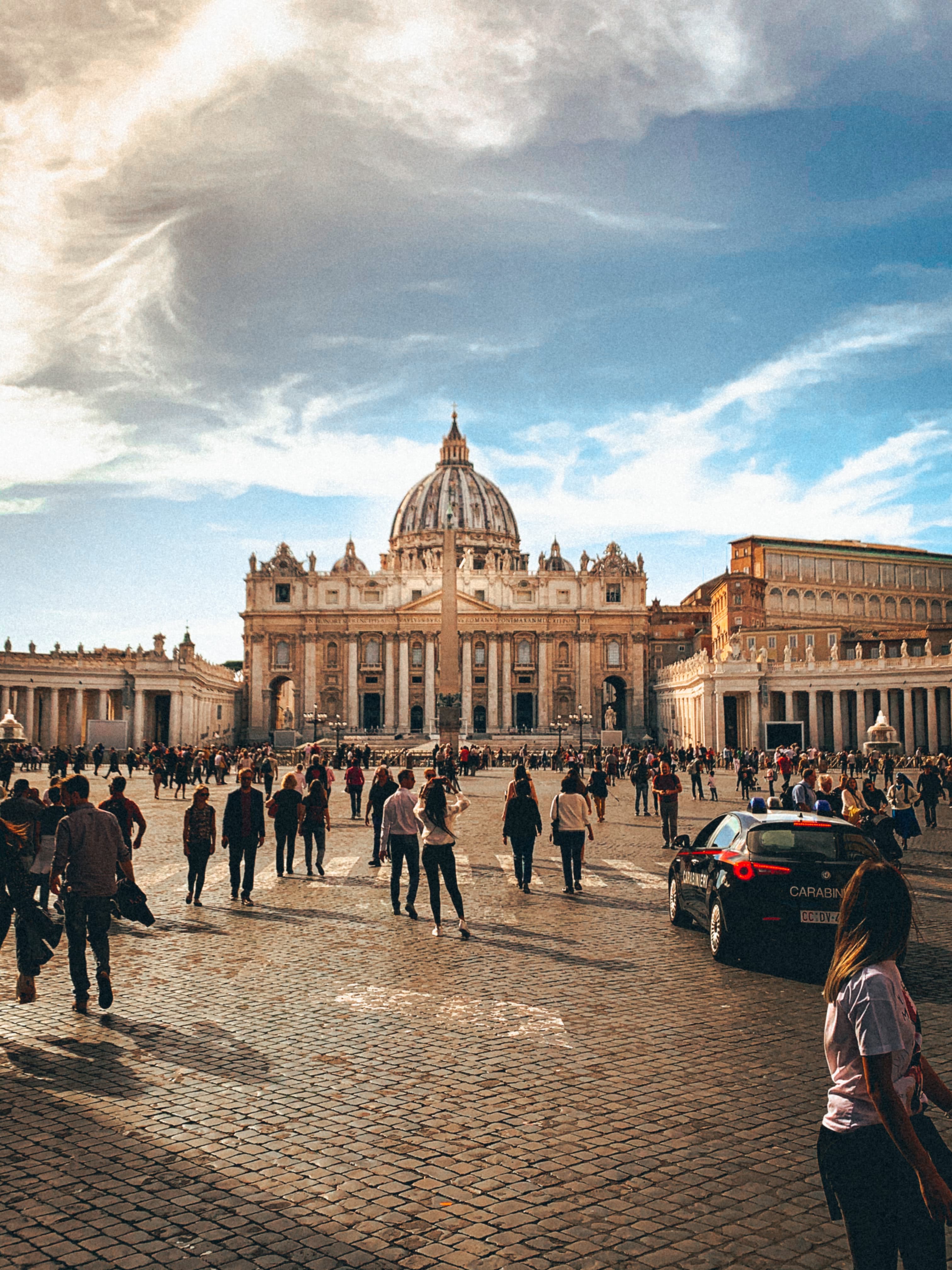 people standing in front of large stone building during daytime
