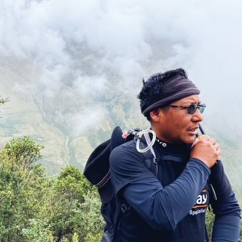 A man standing on a mountain in daytime.