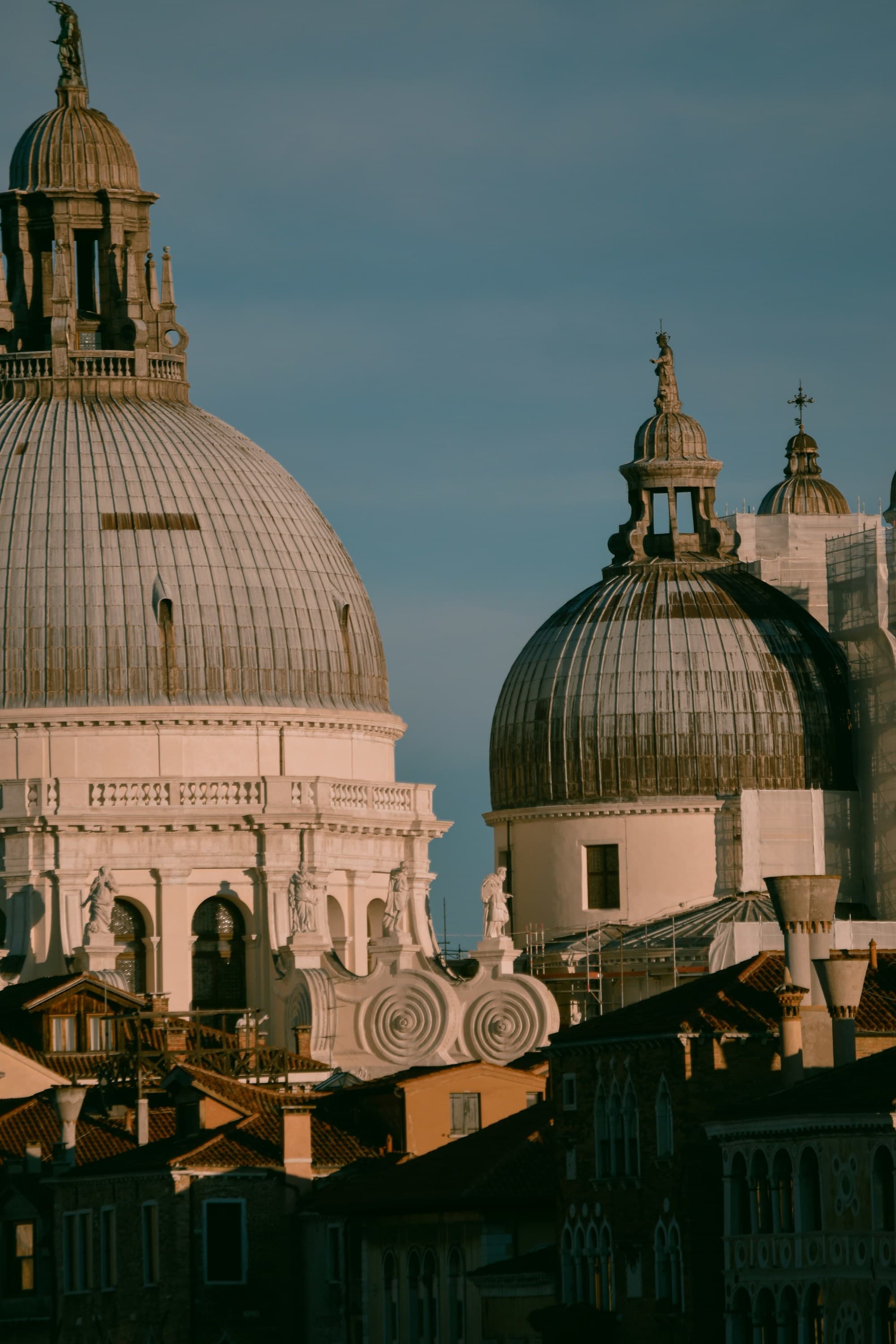 A picture of a large brown building with a domed roof during the daytime.
