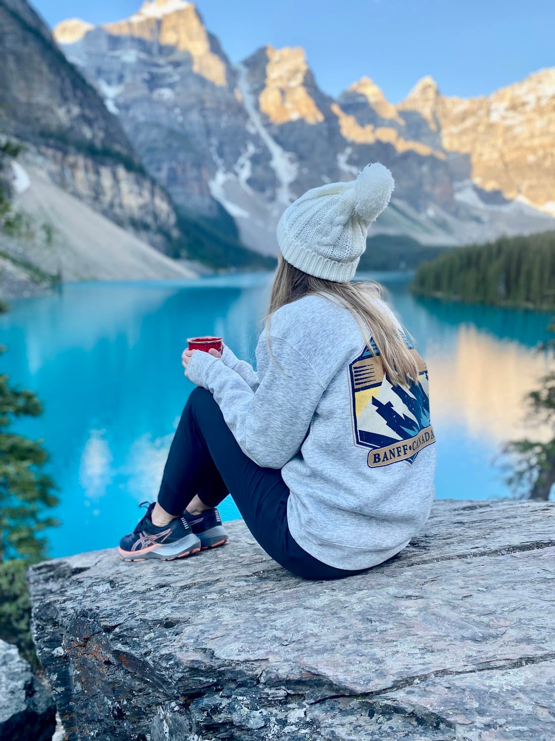 A girl sitting on a Lake in Lake Banff.