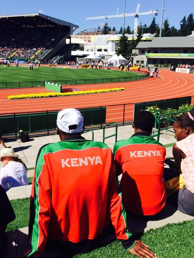 A track field with spectators watching wearing Kenya jerseys.