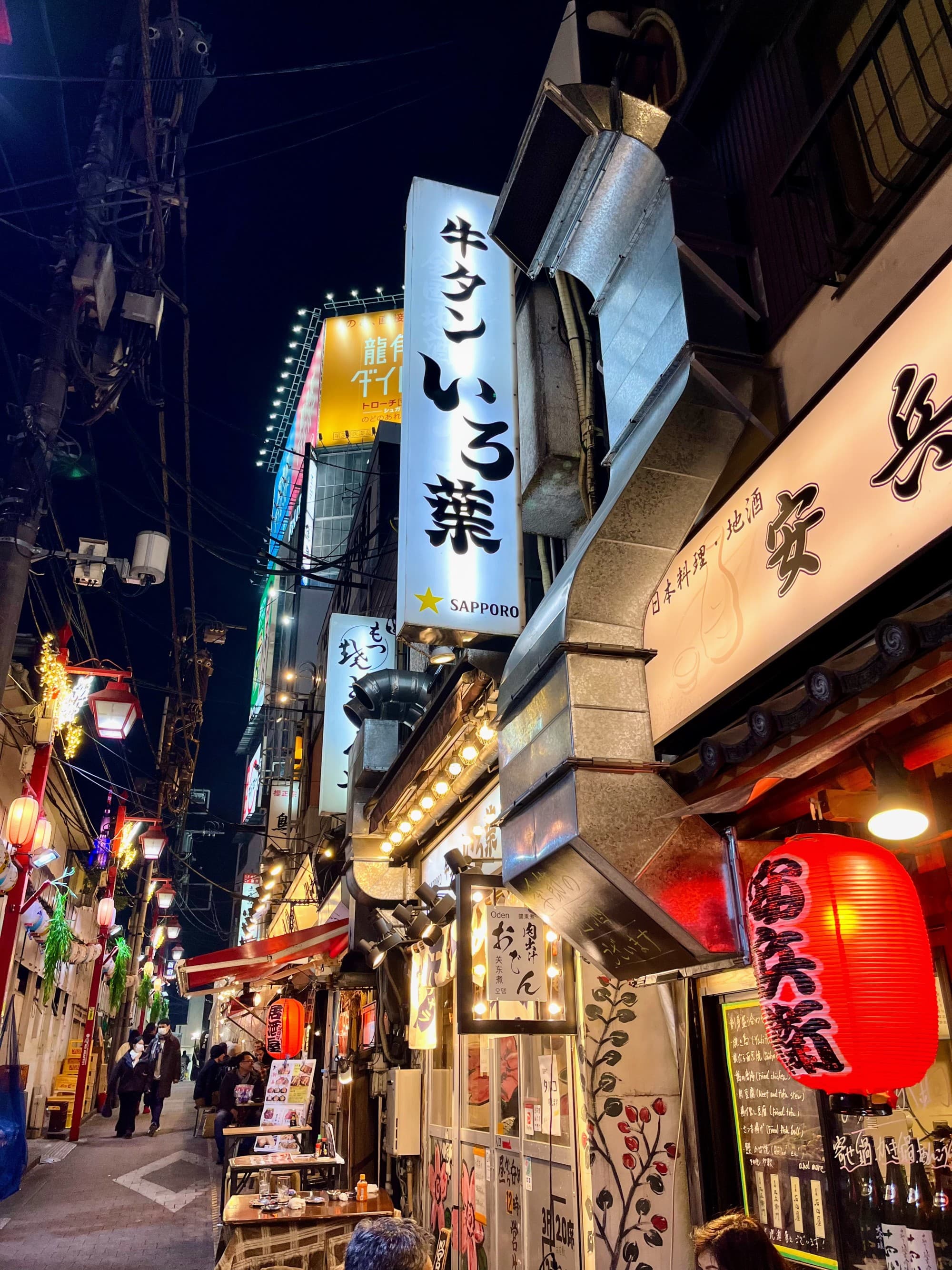 Street with well lit shops at night.
