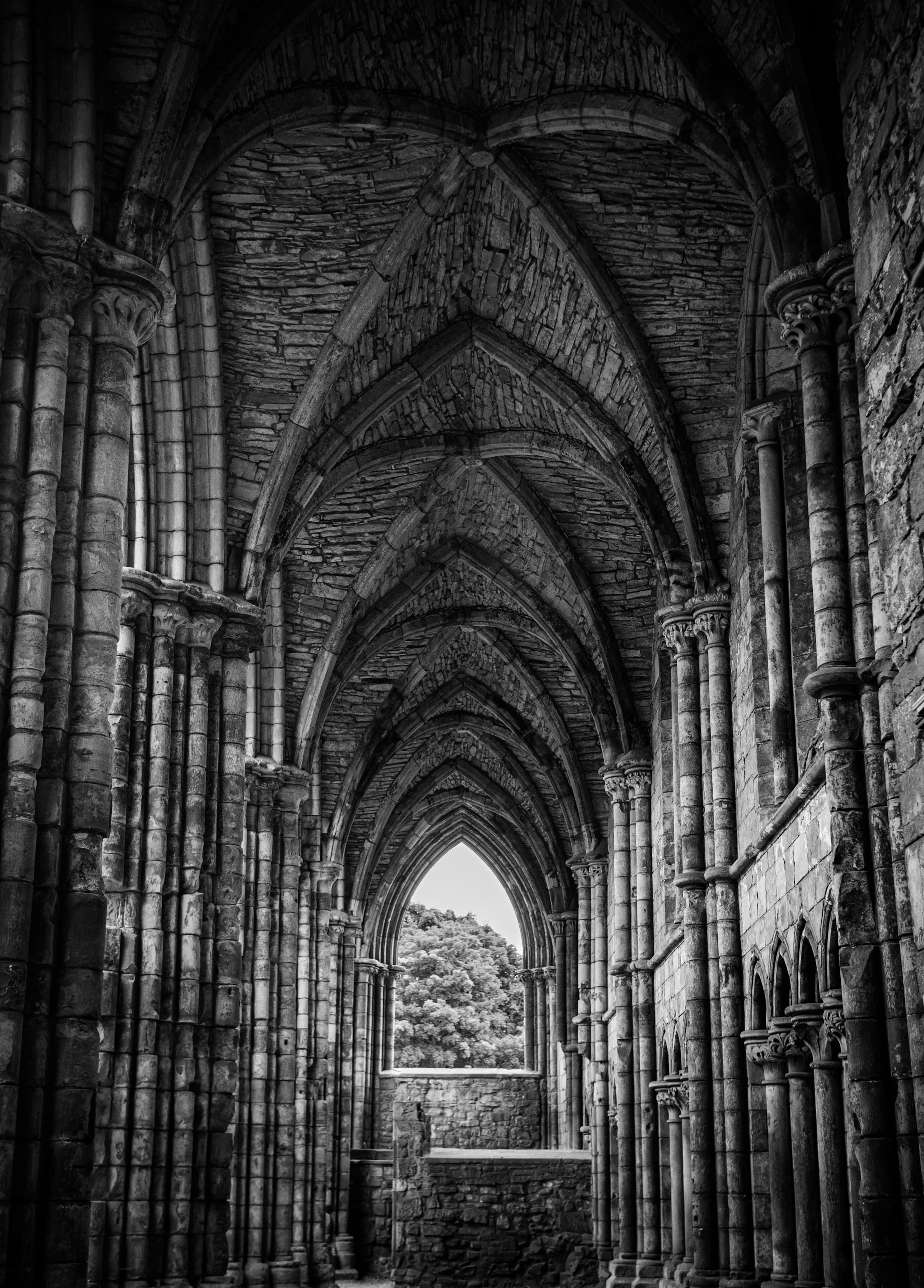 A black and white photo of a corridor in a chapel