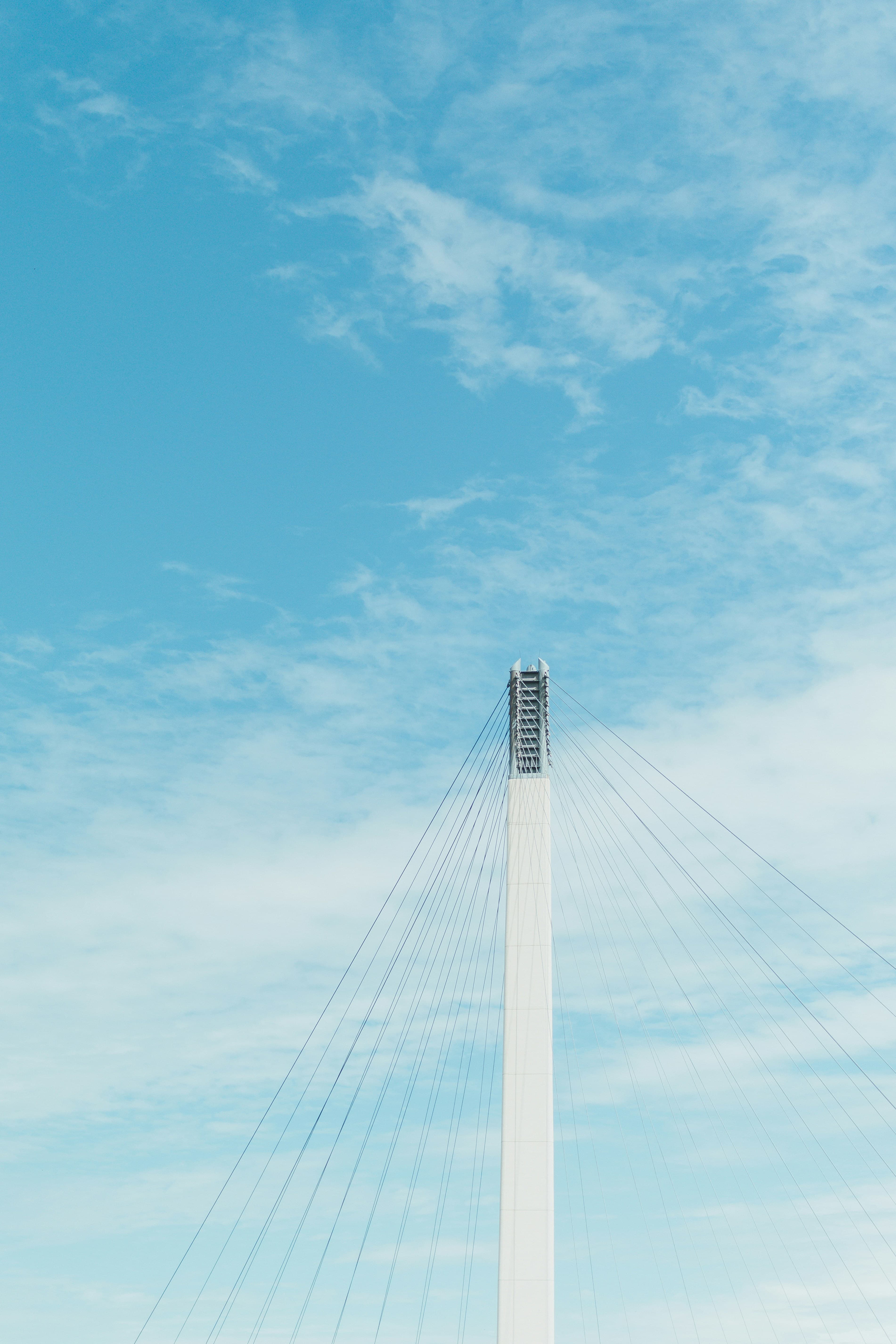 The top of a white bridge spire against a blue sky.